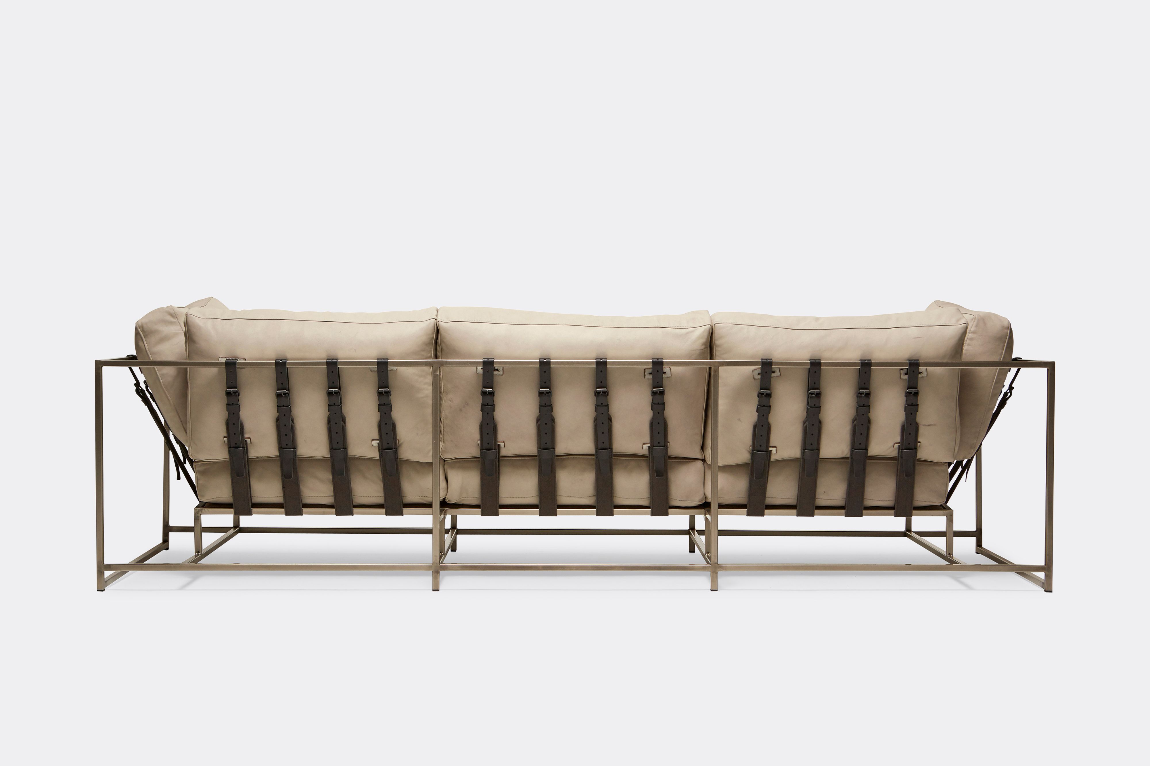 back of Sofa with cream leather upholstery and black leather belts on antique nickel metal frame