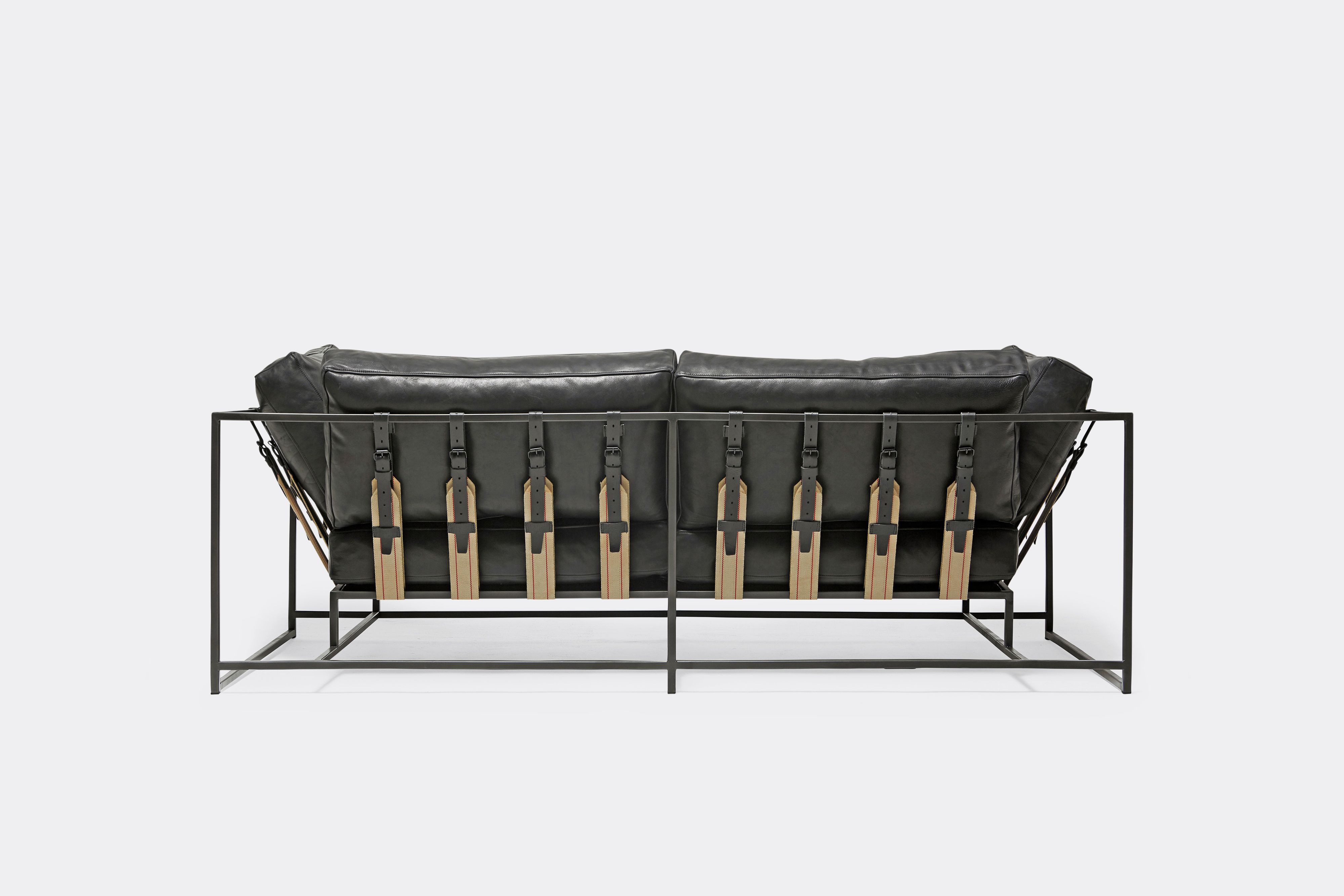 back of two seat sofa black leather upholstery and black leather belts on black metal frame