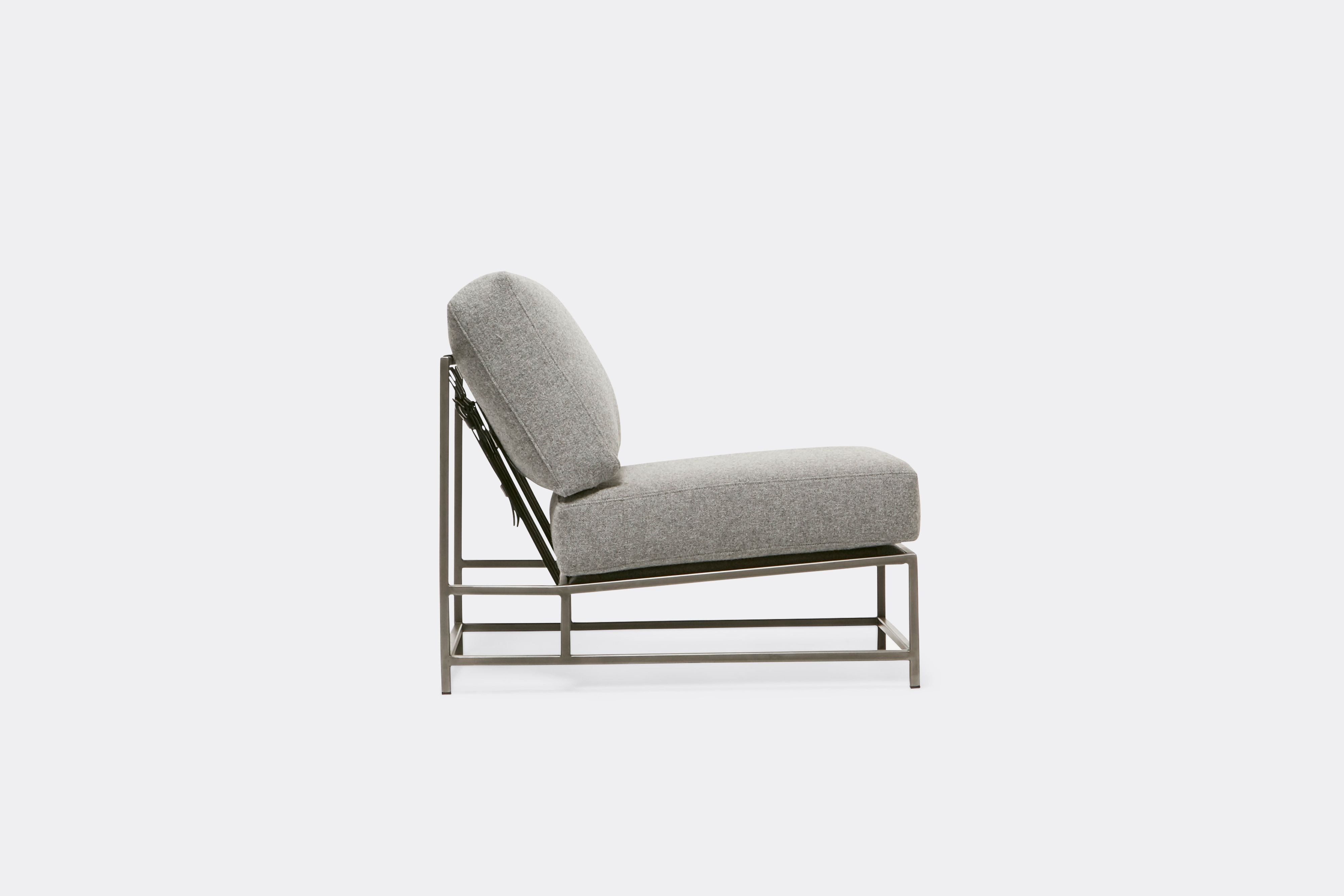 Sideview of lounge chair with grey wool upholstery and antique nickel metal frame