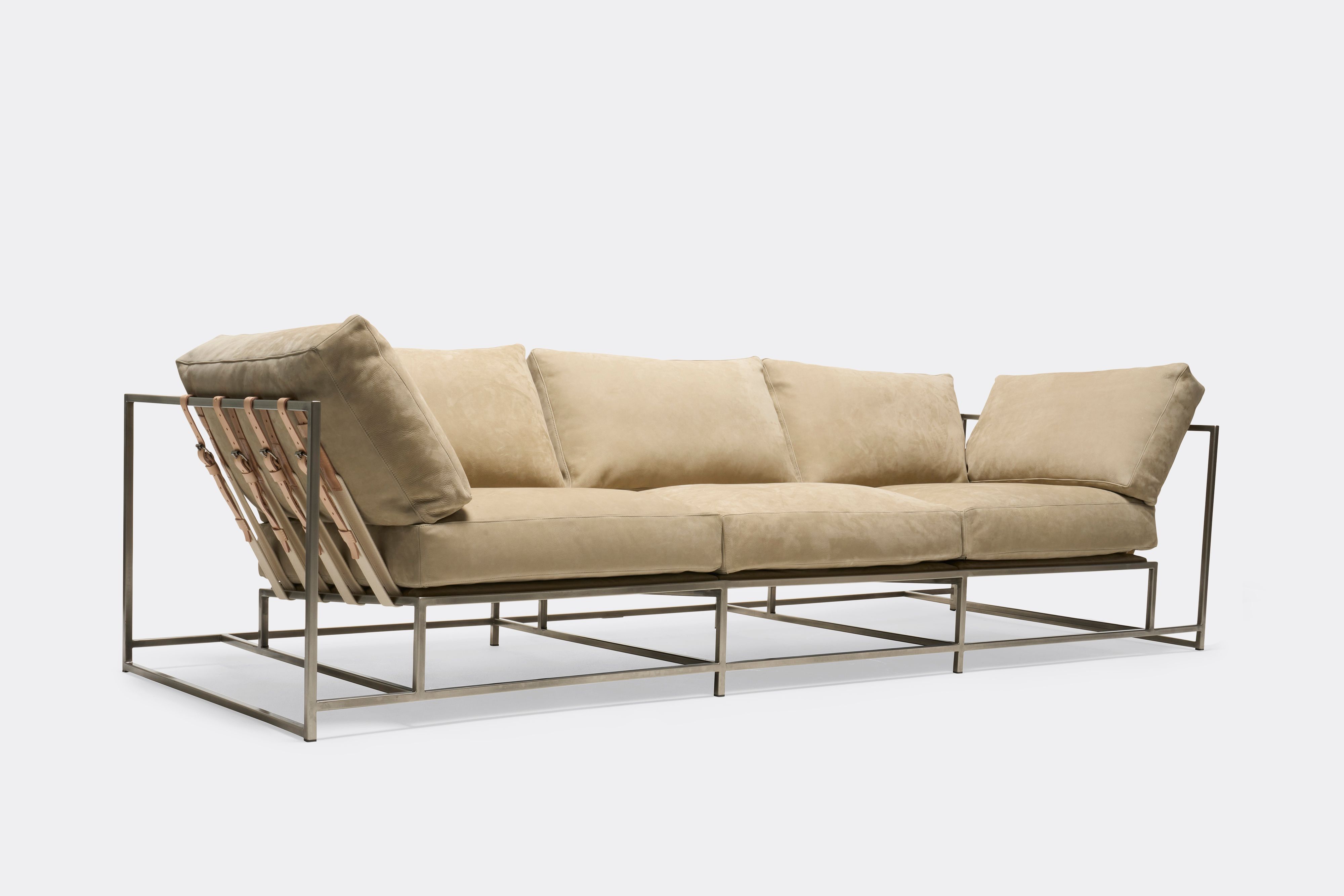 sideview of Sofa with tan leather upholstery and antique nickel metal frame