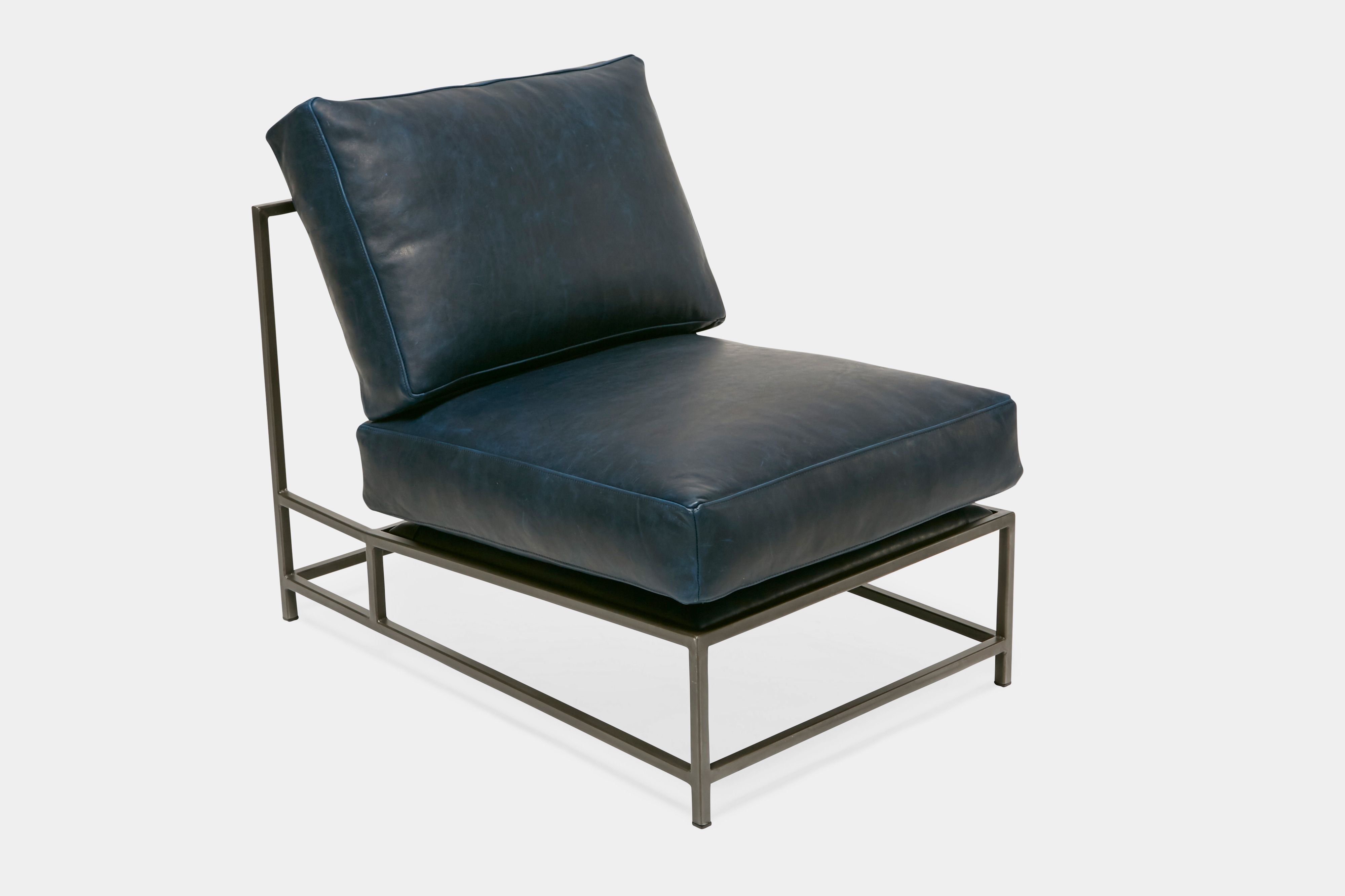 side of lounge chair with blue leather upholstery on antique nickel metal frame