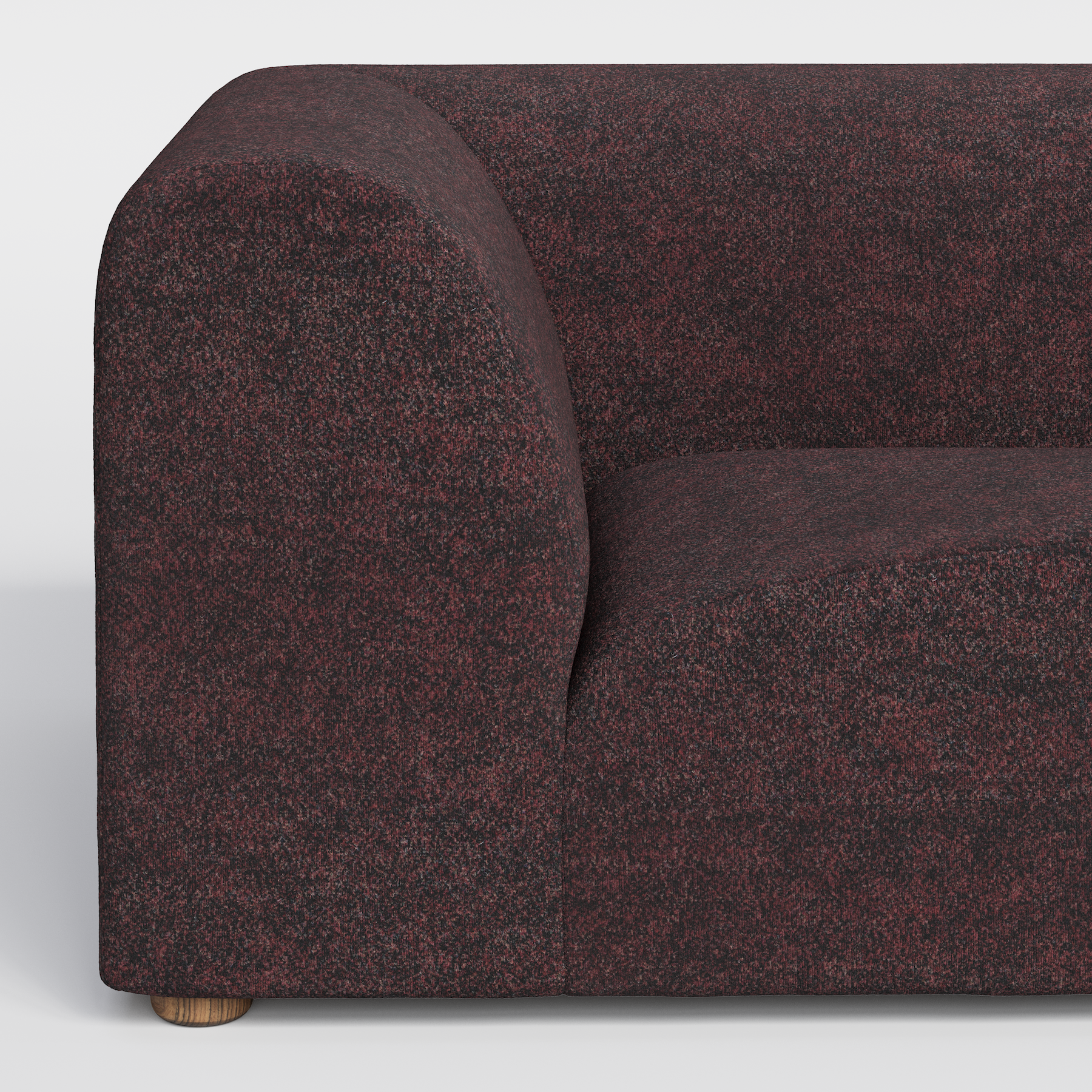 A dark red speckled fabric sofa with a rounded armrest and a wooden leg.
