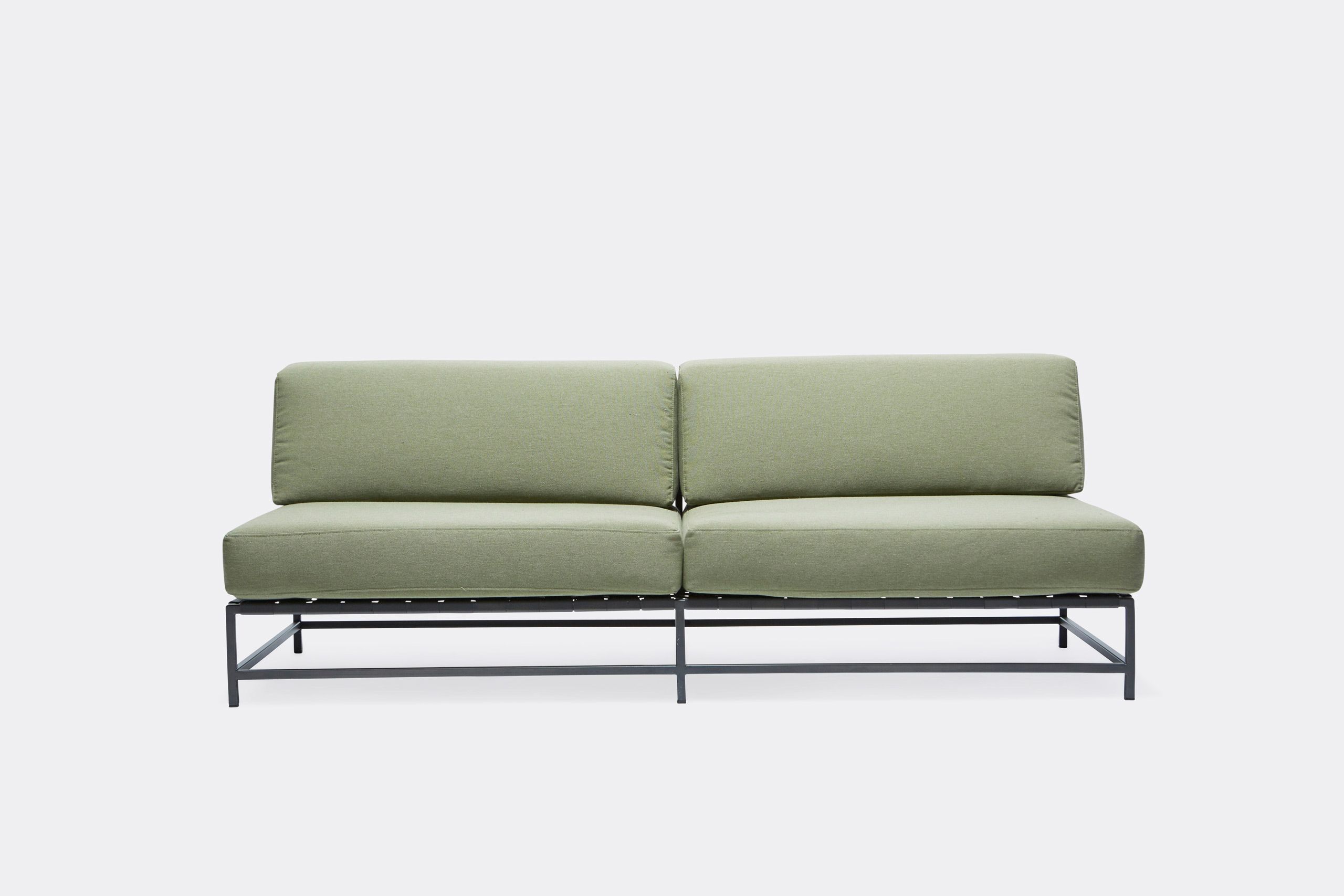 a steel framed sofa with black metal finish and green cushions and supporting belts on a white background .