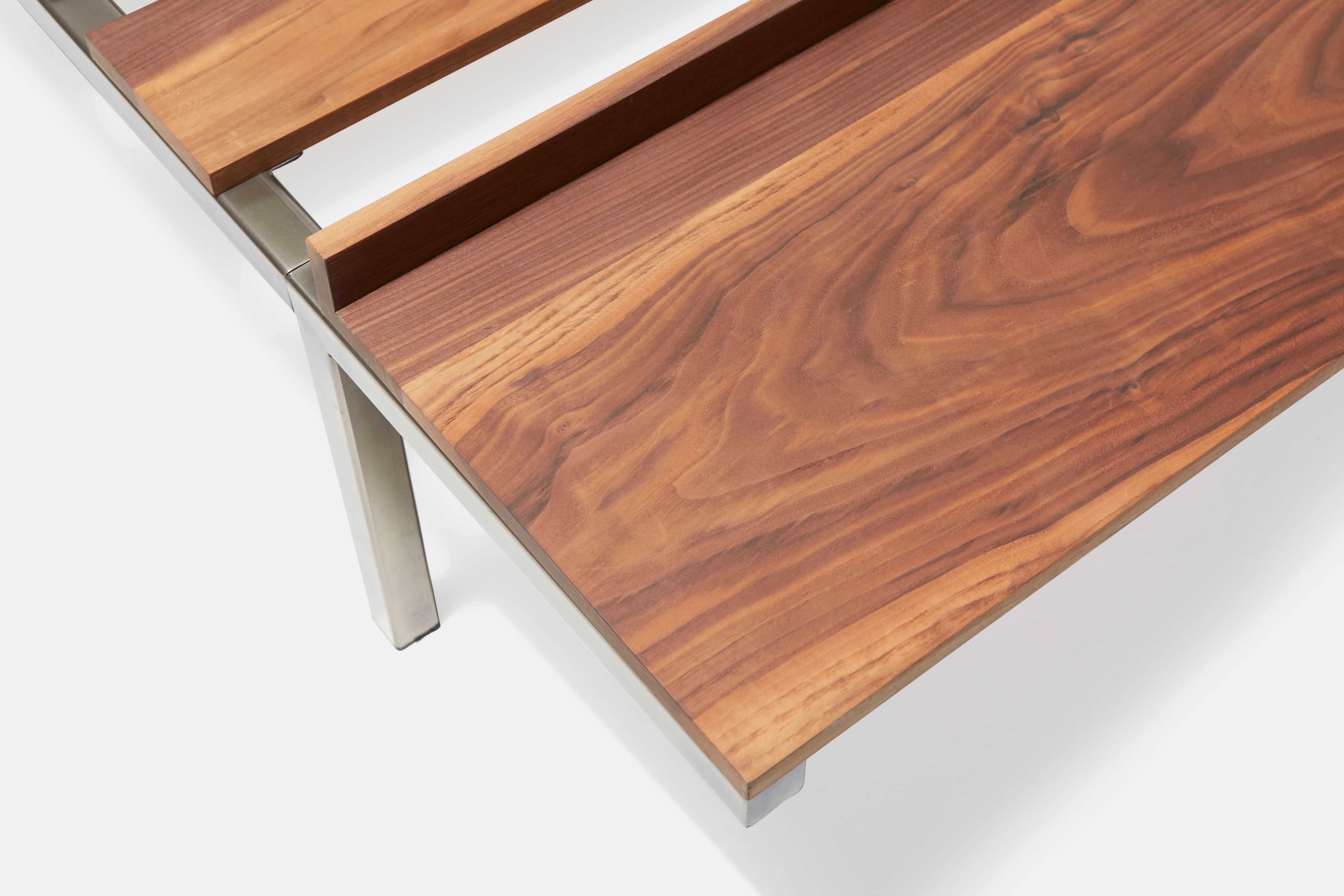 a steel and walnut wood bed with a brown leather headboard on a white background