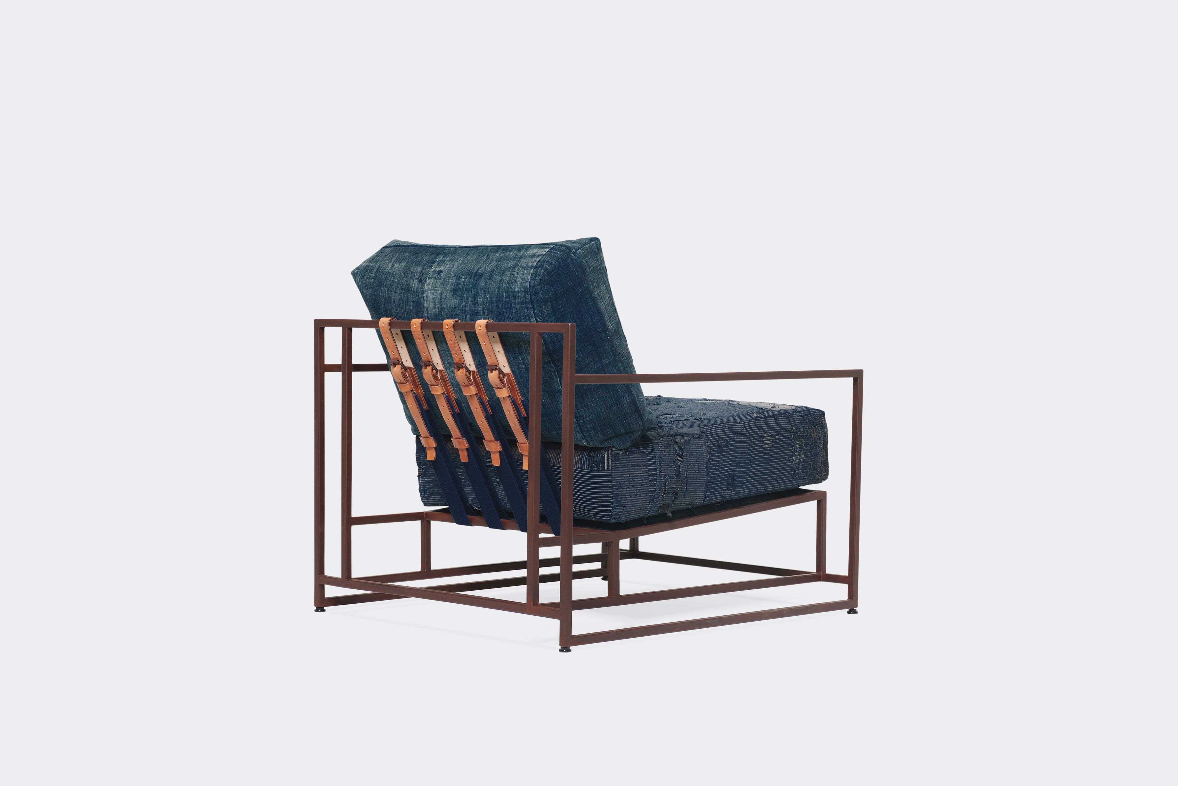 back of armchair with vintage boro upholstery and brown leather belts on marbled rust metal frame