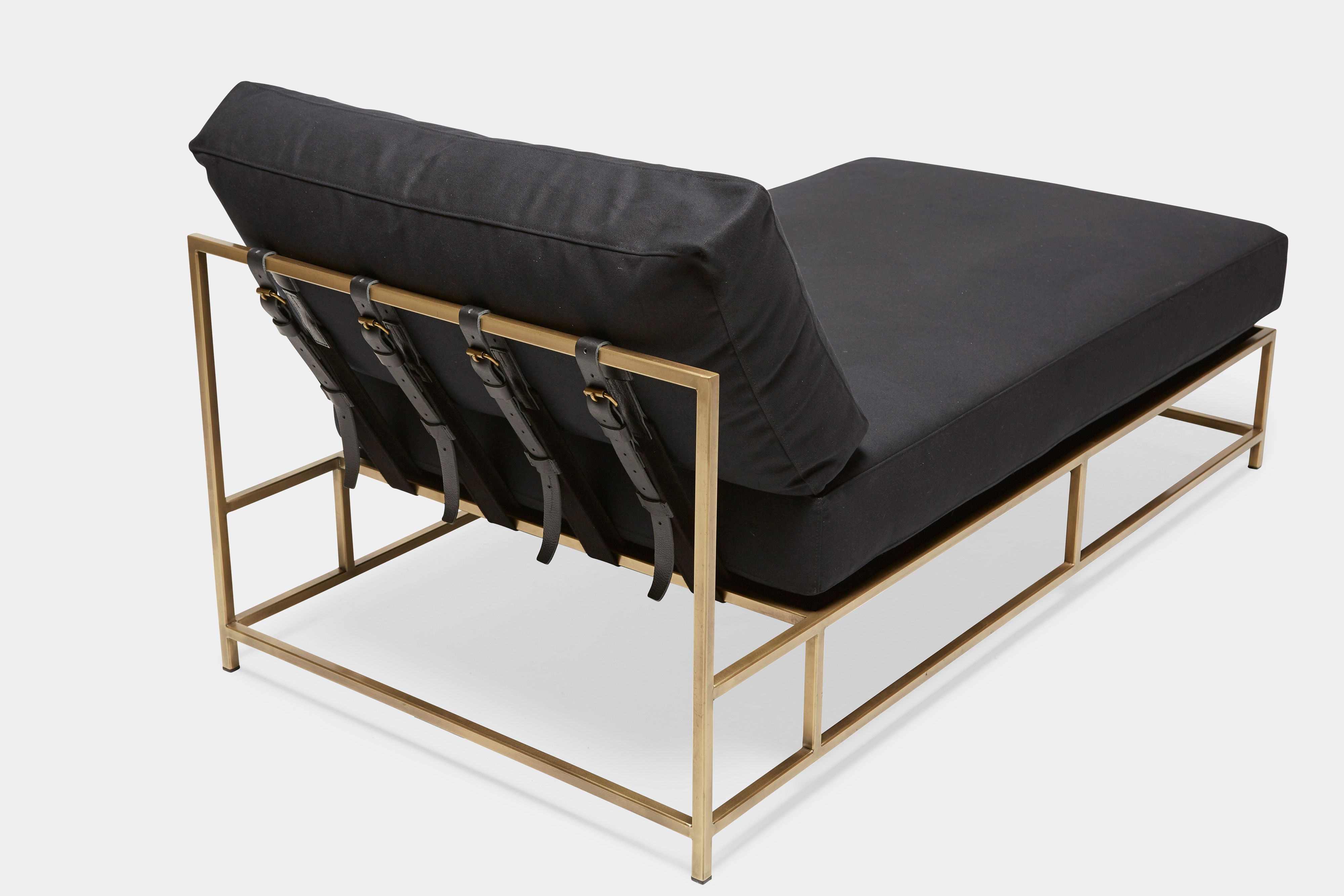 overhead view of Chaise Lounge with black canvas upholstery and black leather belts on antique brass metal frame