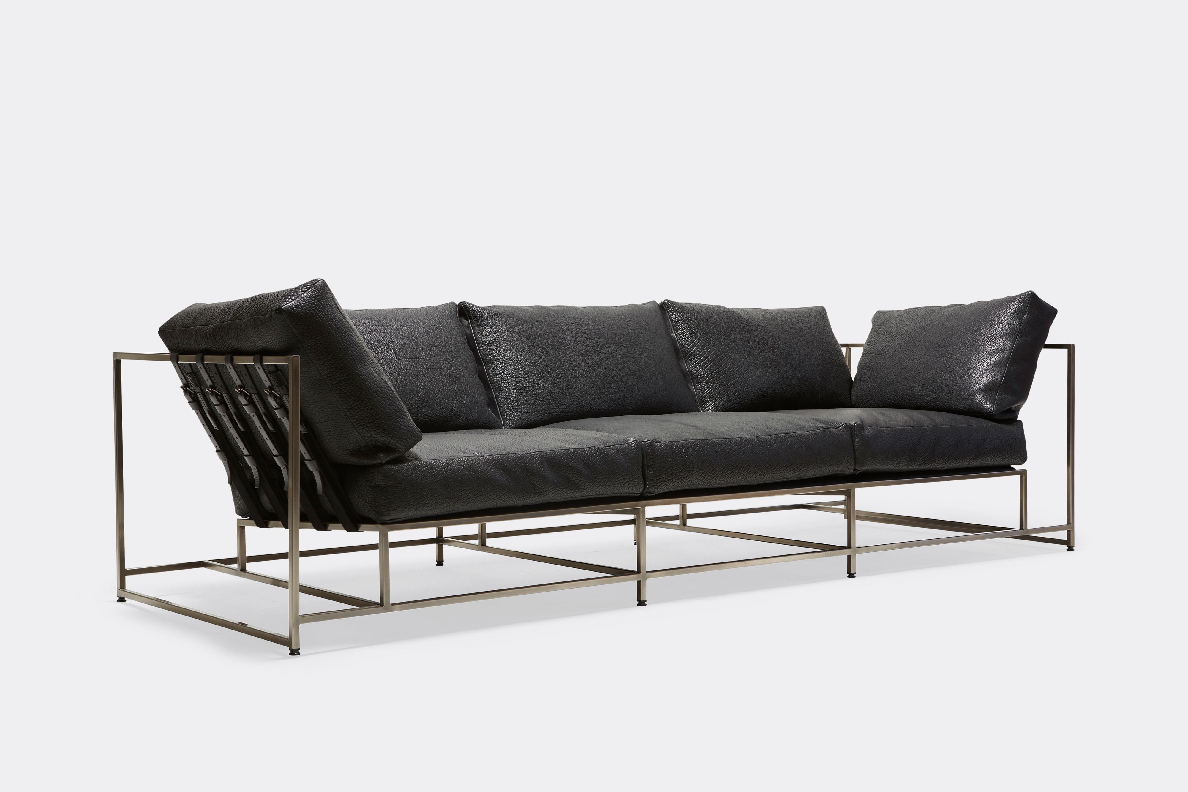 sideview of Sofa with black leather upholstery and black leather belts on antique nickel metal frame