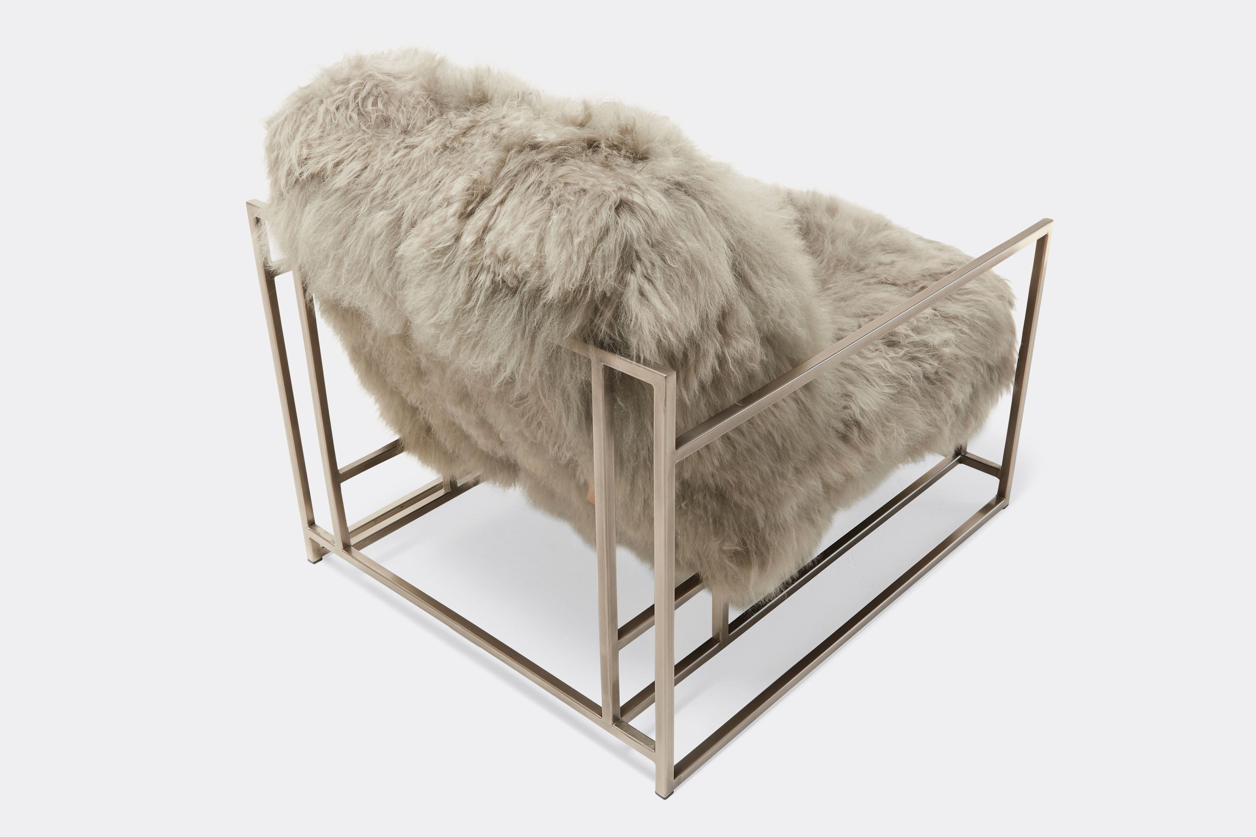 overhead of armchair with grey sheepskin upholstery on antique nickel frame