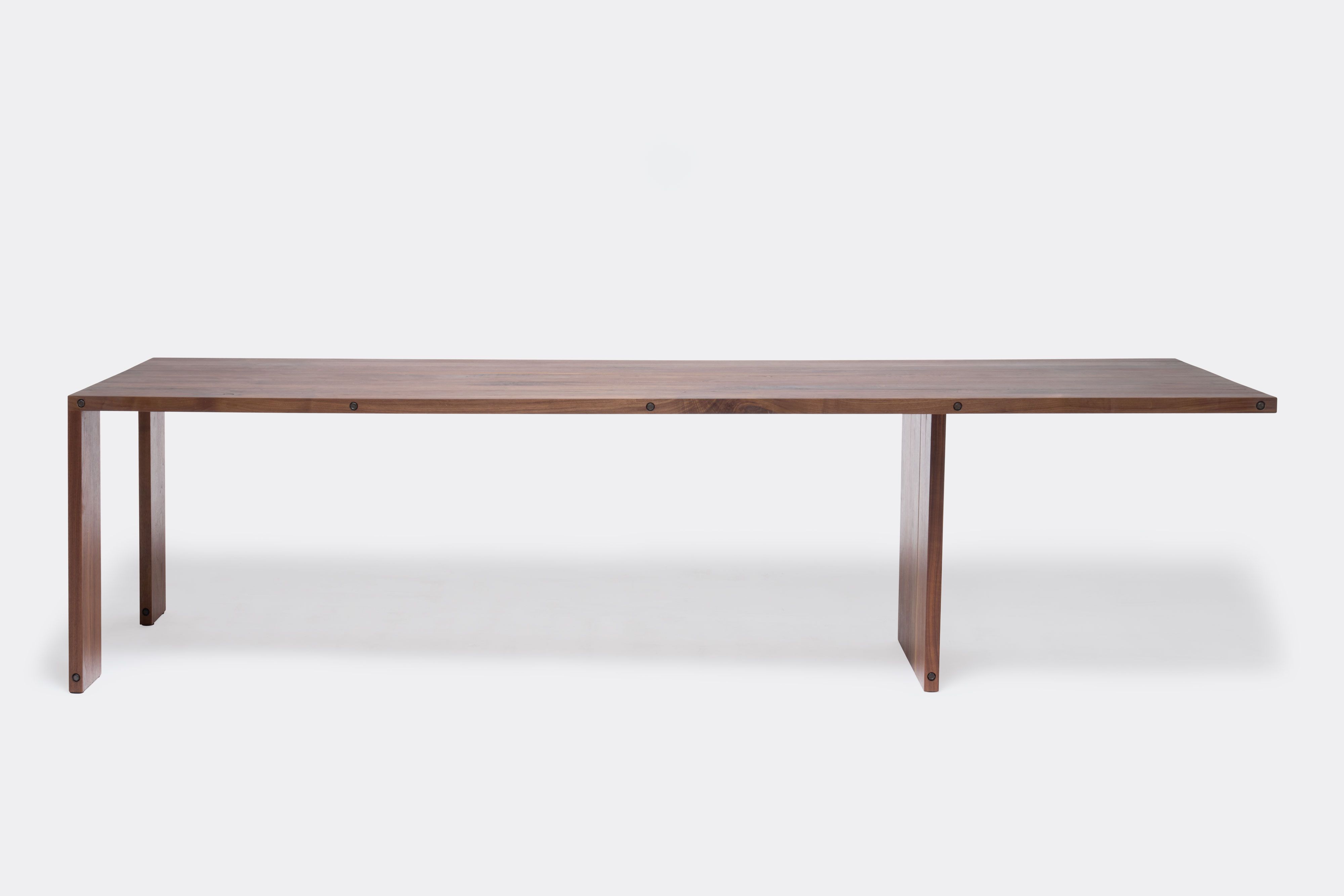 a long walnut wooden table on a white background .