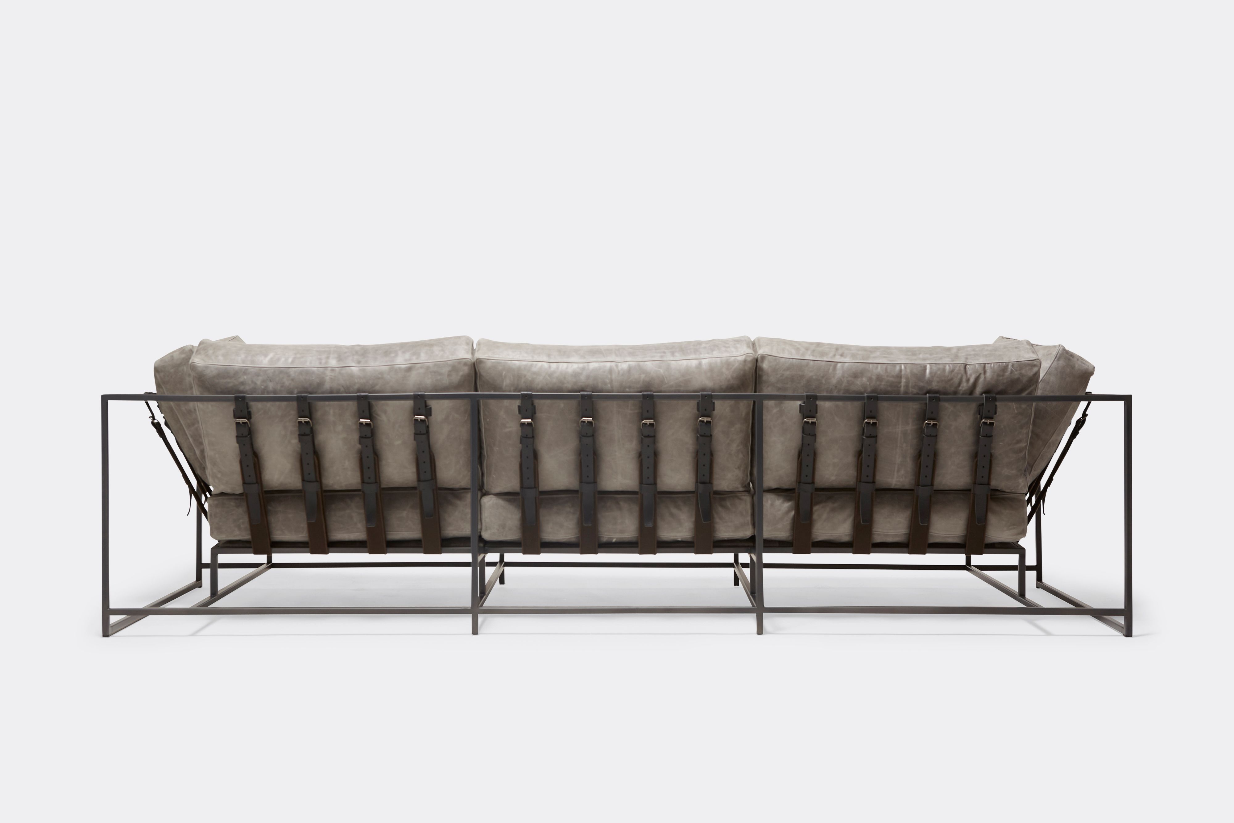 Back of Sofa with gray leather upholstery and black leather belts on gray powdercoat metal frame
