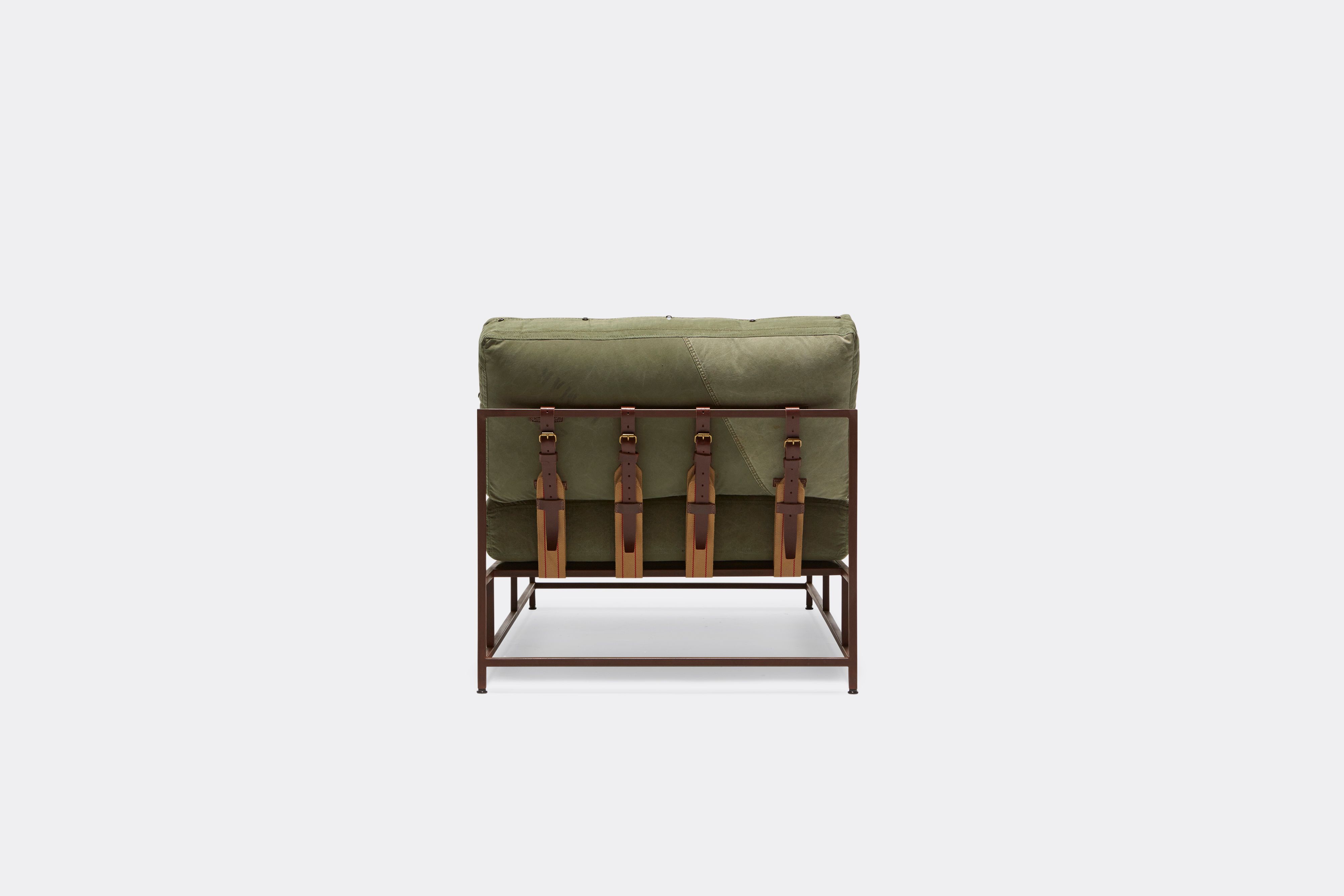 Back of lounge chaise with military canvas upholstery and brown leather belts on marble rust metal frame