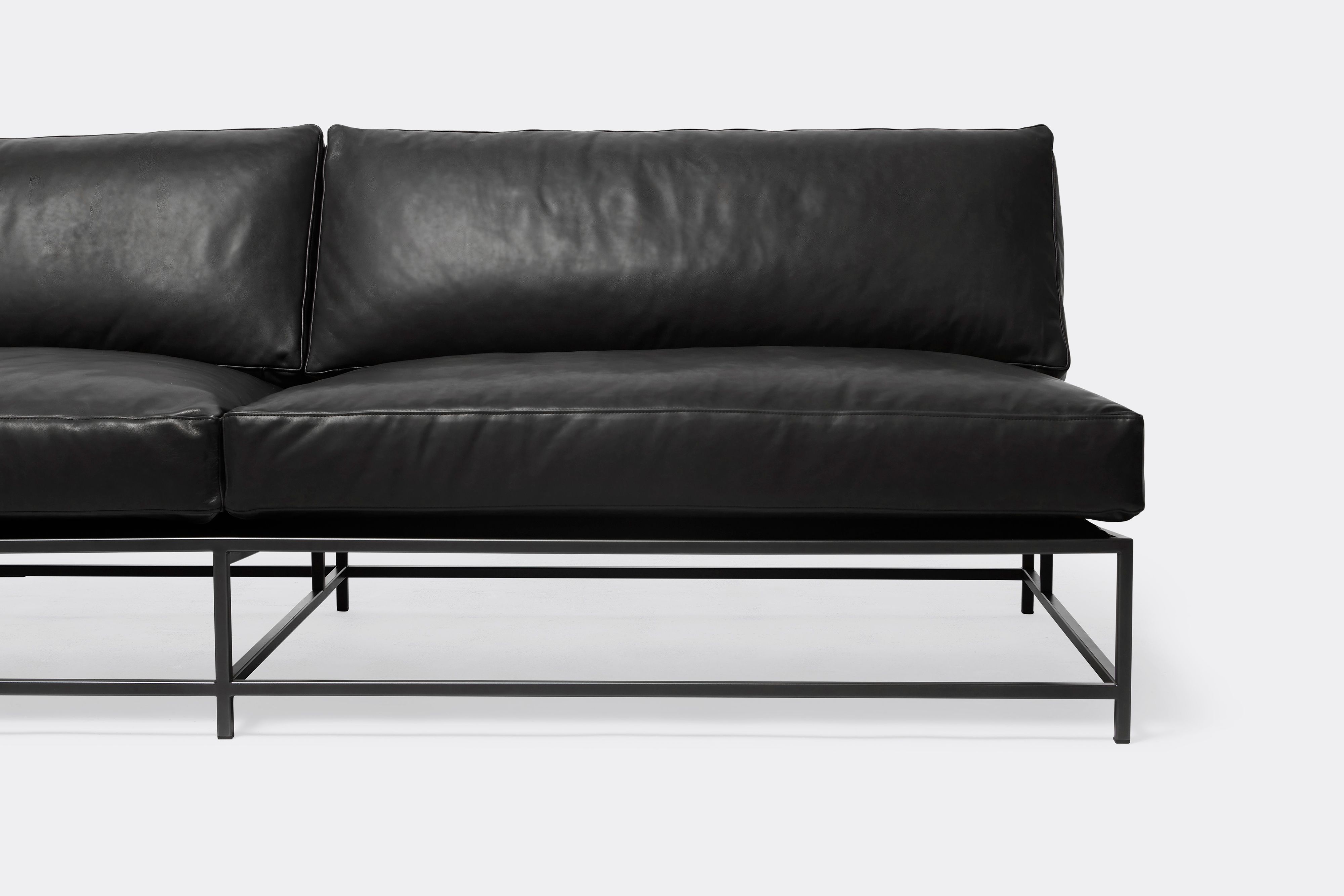 detail view of loveseat with black leather upholstery on black metal frame