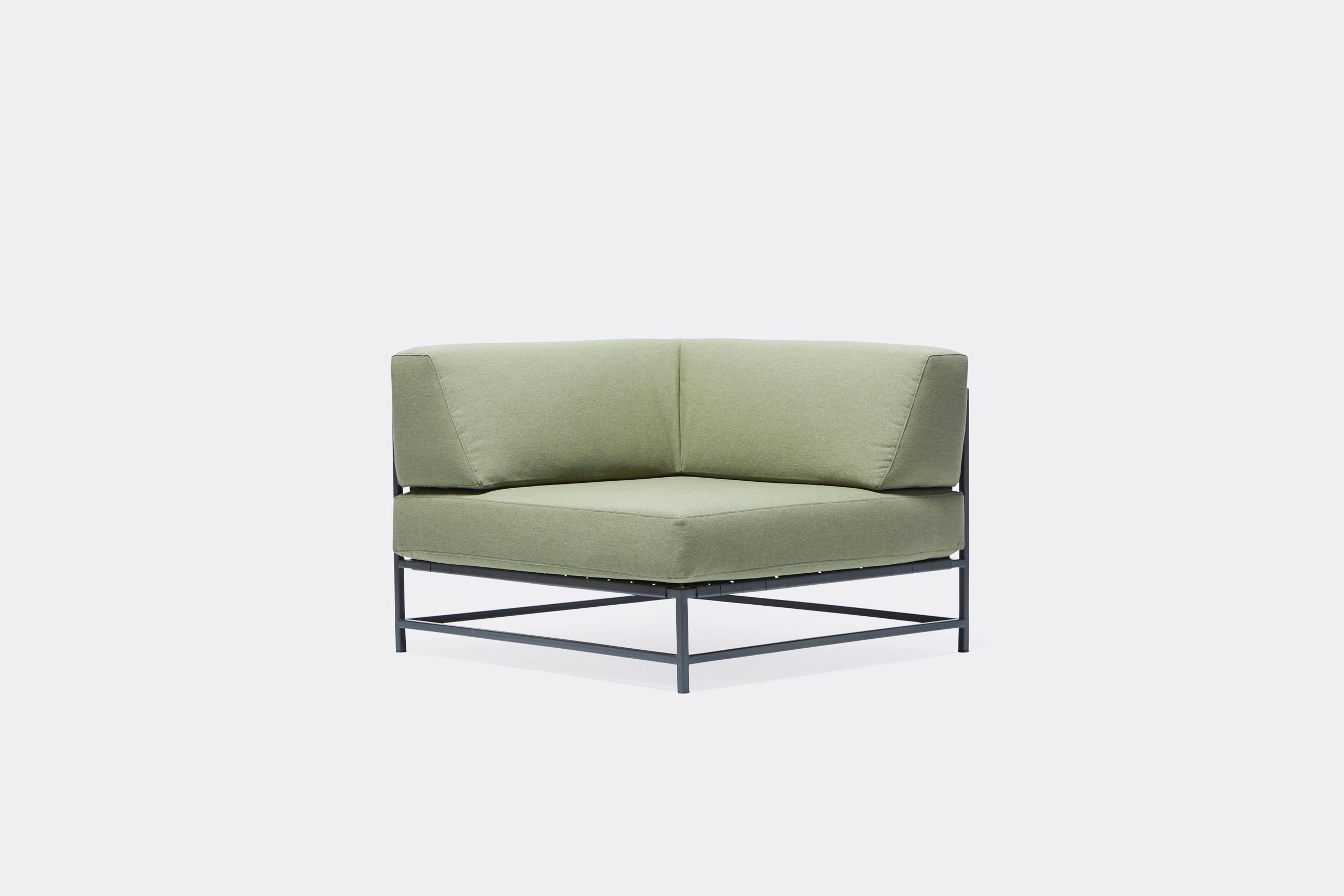 An outdoor chair with steel frame in black finish and green cushions and supporting belts