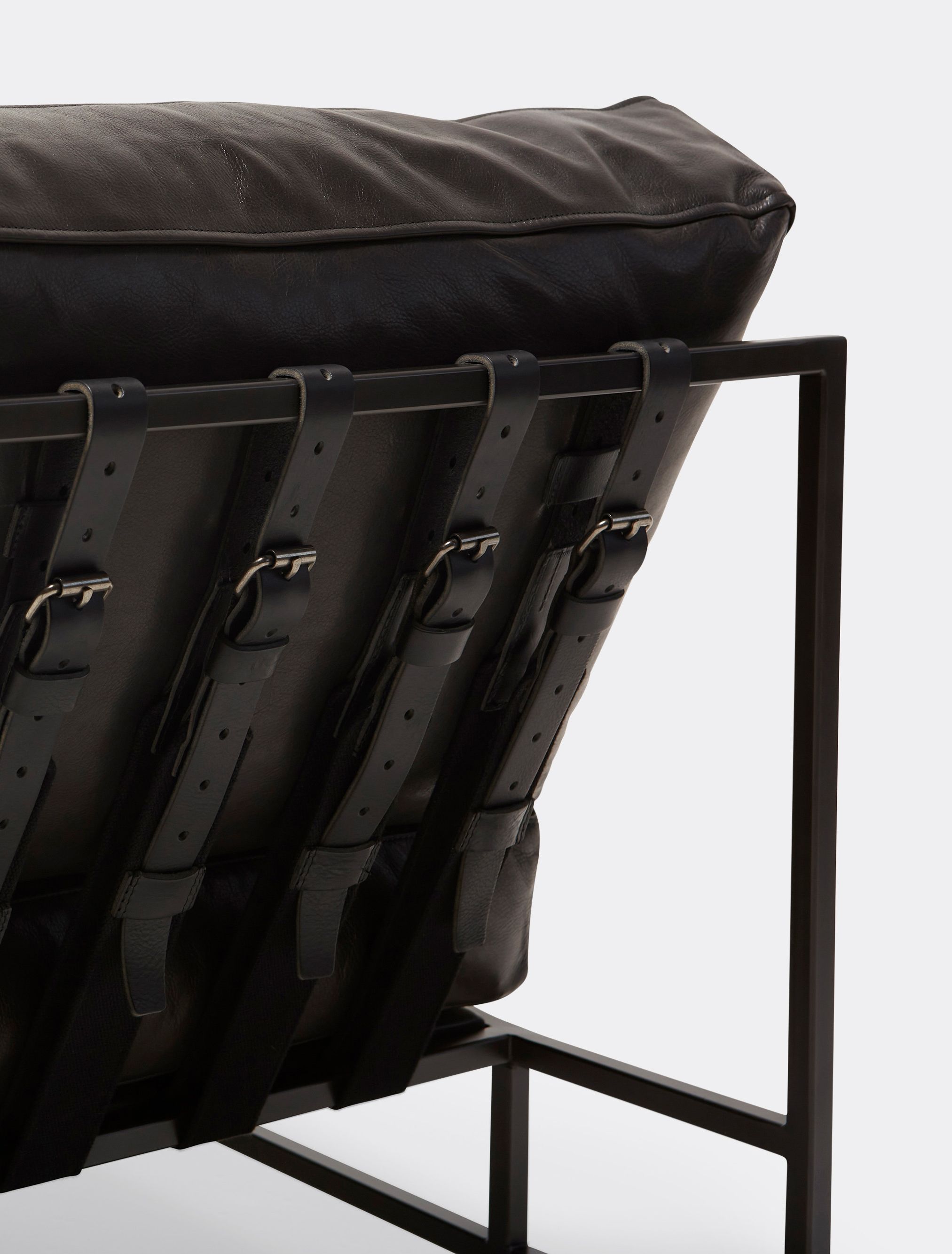  a black leather chair on a black steel frame with black supporting belts shown on a white background