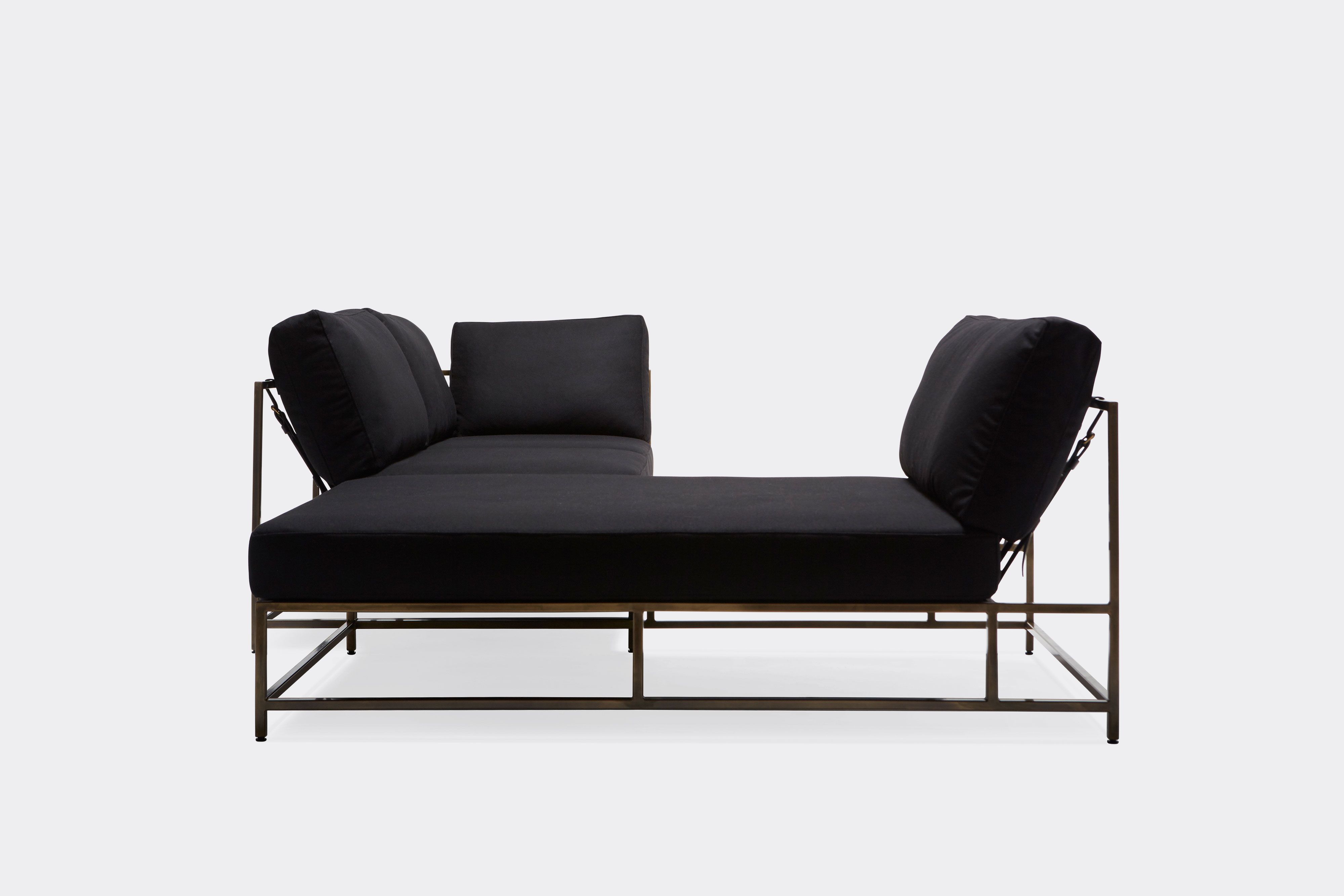 side of sectional with black wool upholstery on antique brass metal frame