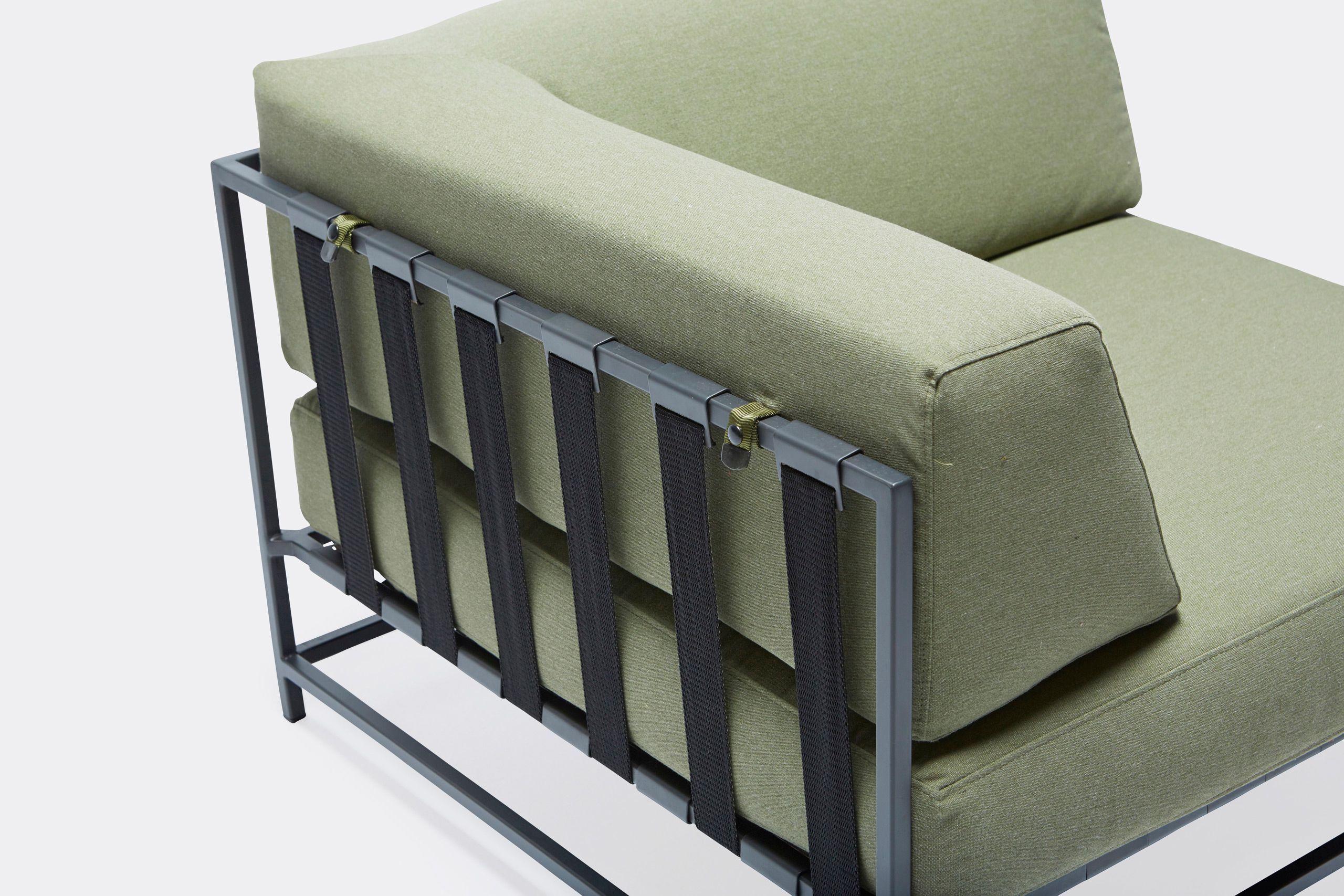 An outdoor chair with steel frame in black finish and green cushions and supporting belts