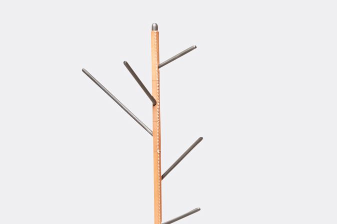 a steel coat rack with stitched leather details and a stone base shown on a white background