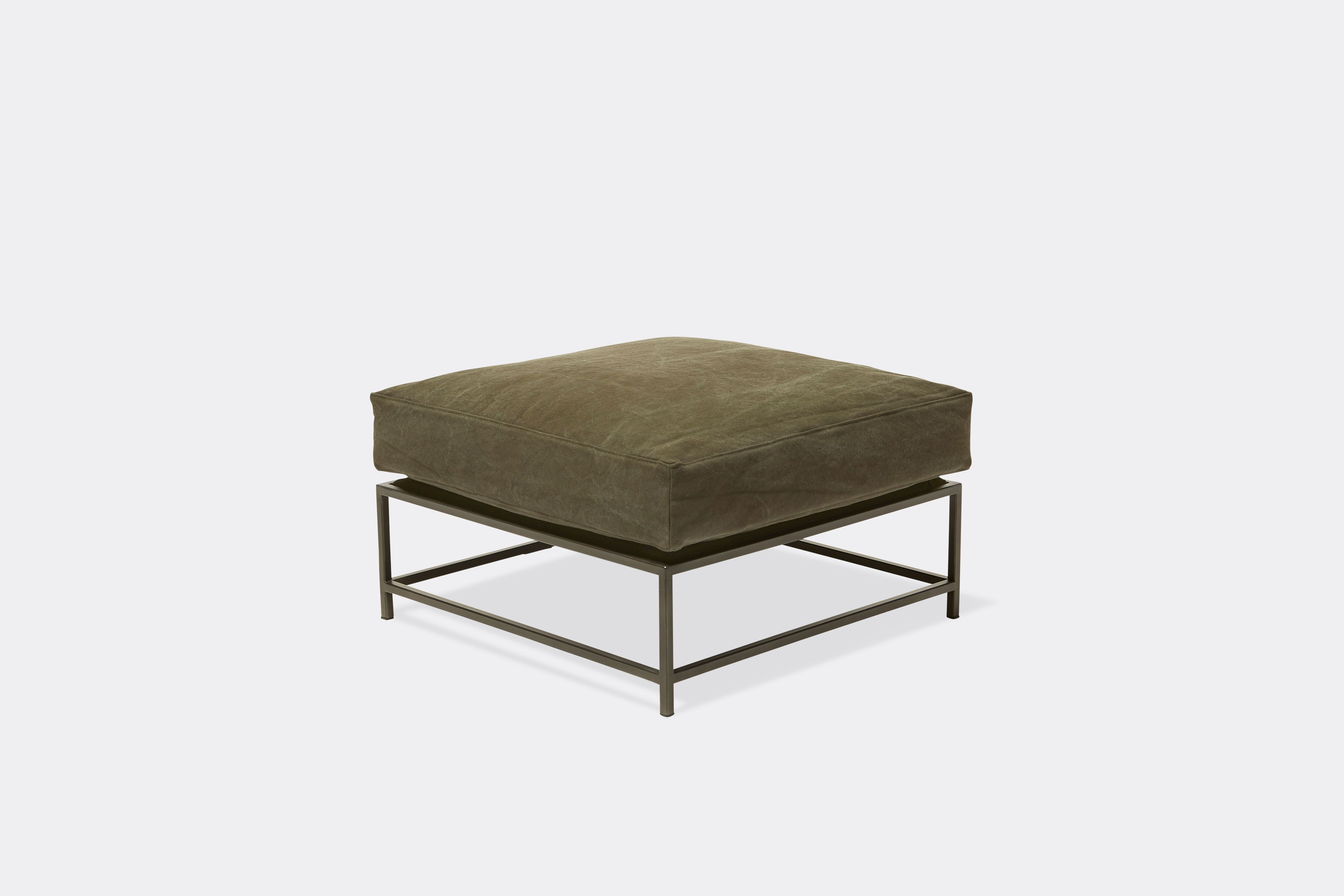 top side view of green canvas ottoman with blackened steel frame