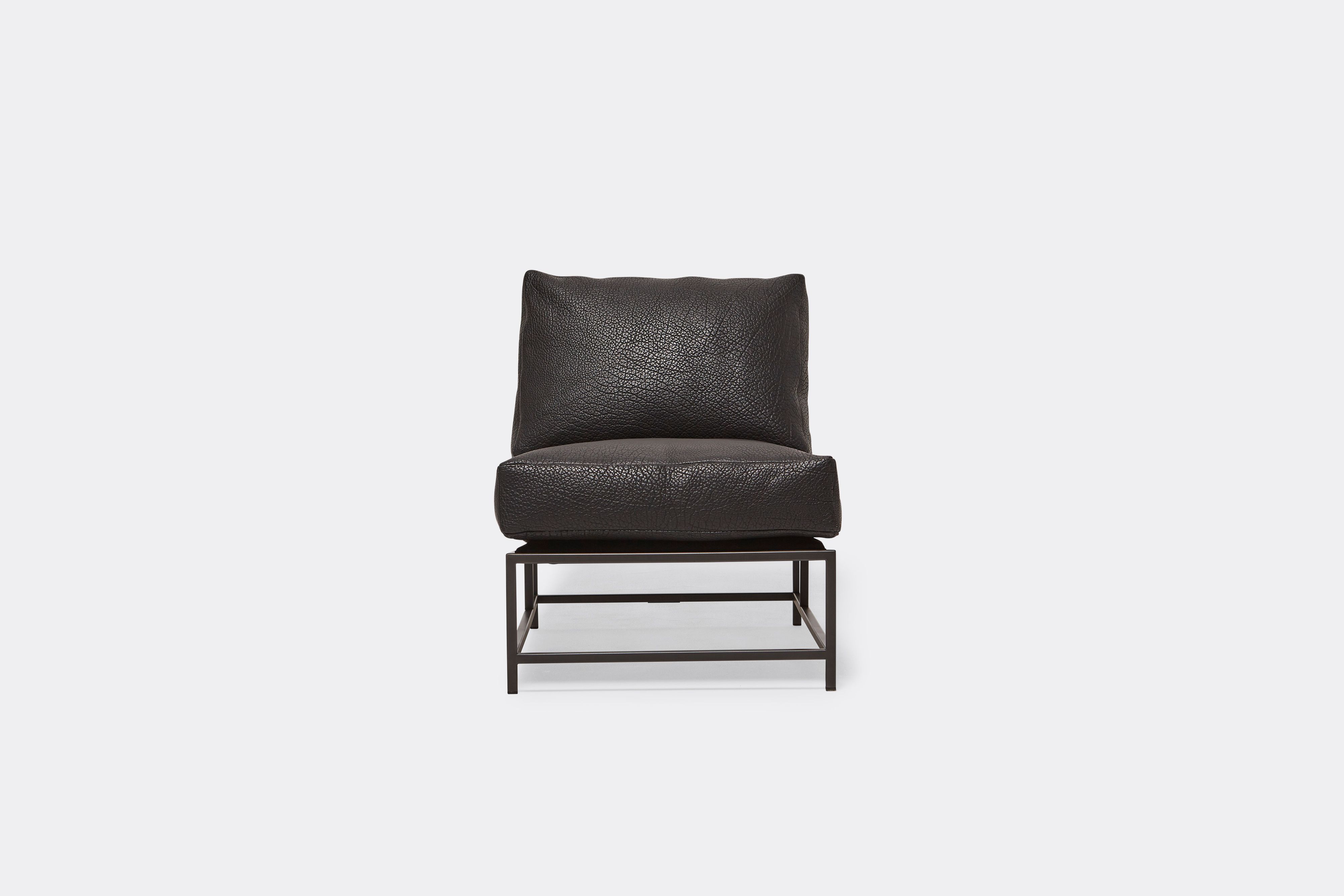 Front of lounge chair with black leather upholstery and black metal frame