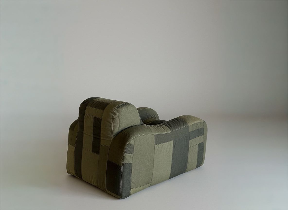 Soft, rounded armchair with two-tone green rectangular fabric panels.