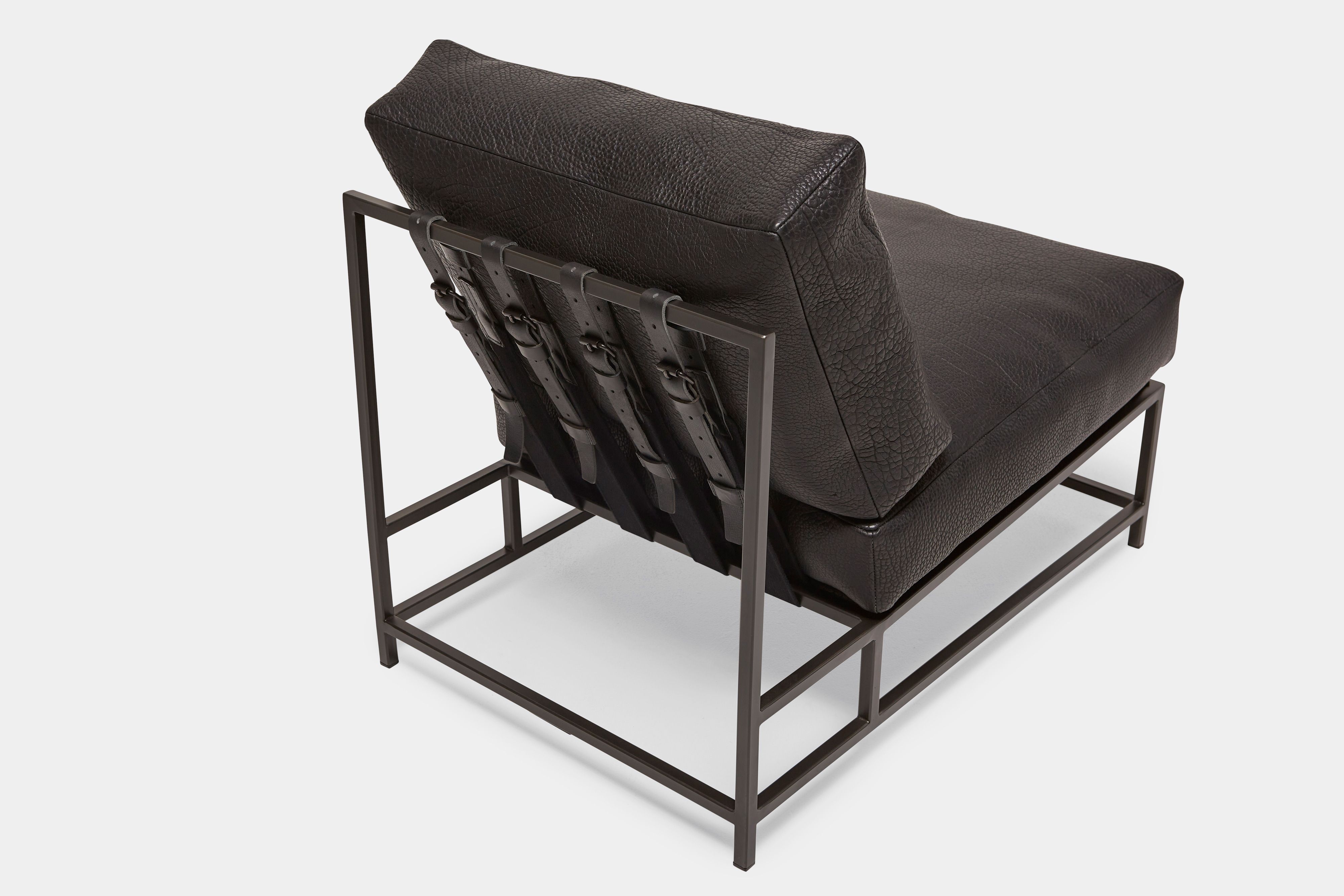 overhead view of lounge chair with black leather upholstery and black leather belts on black metal frame