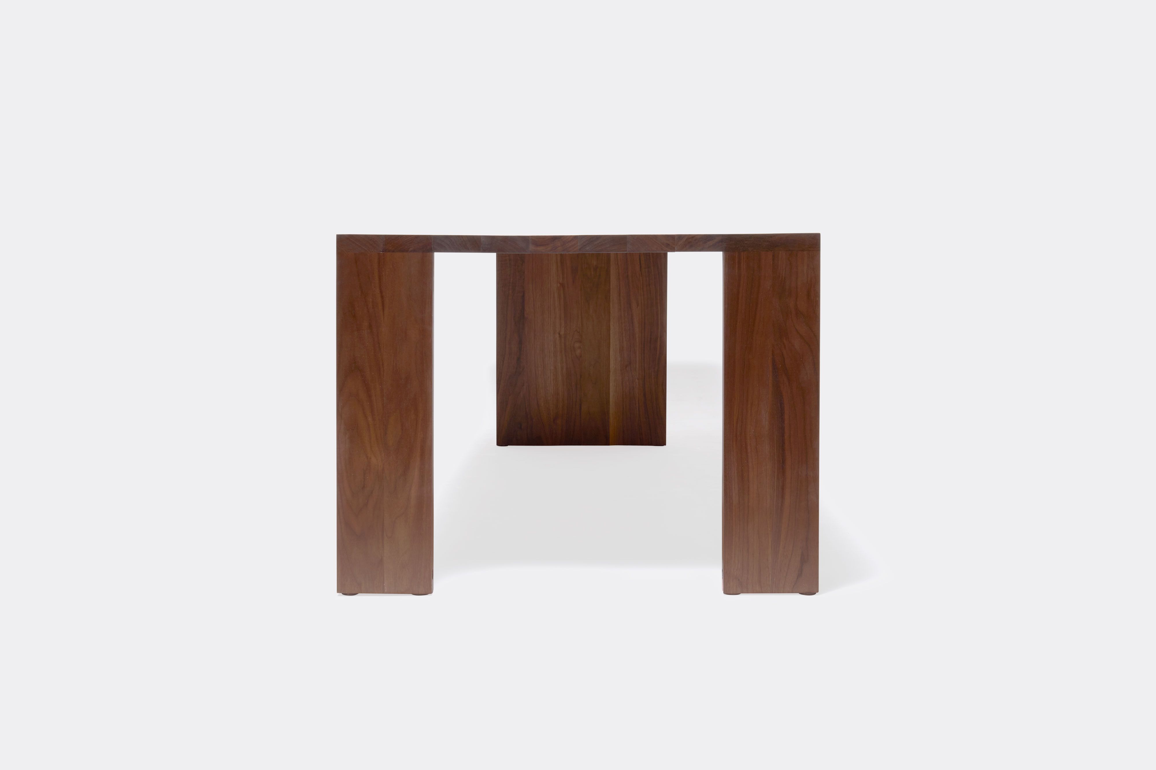 a long walnut wooden table on a white background .