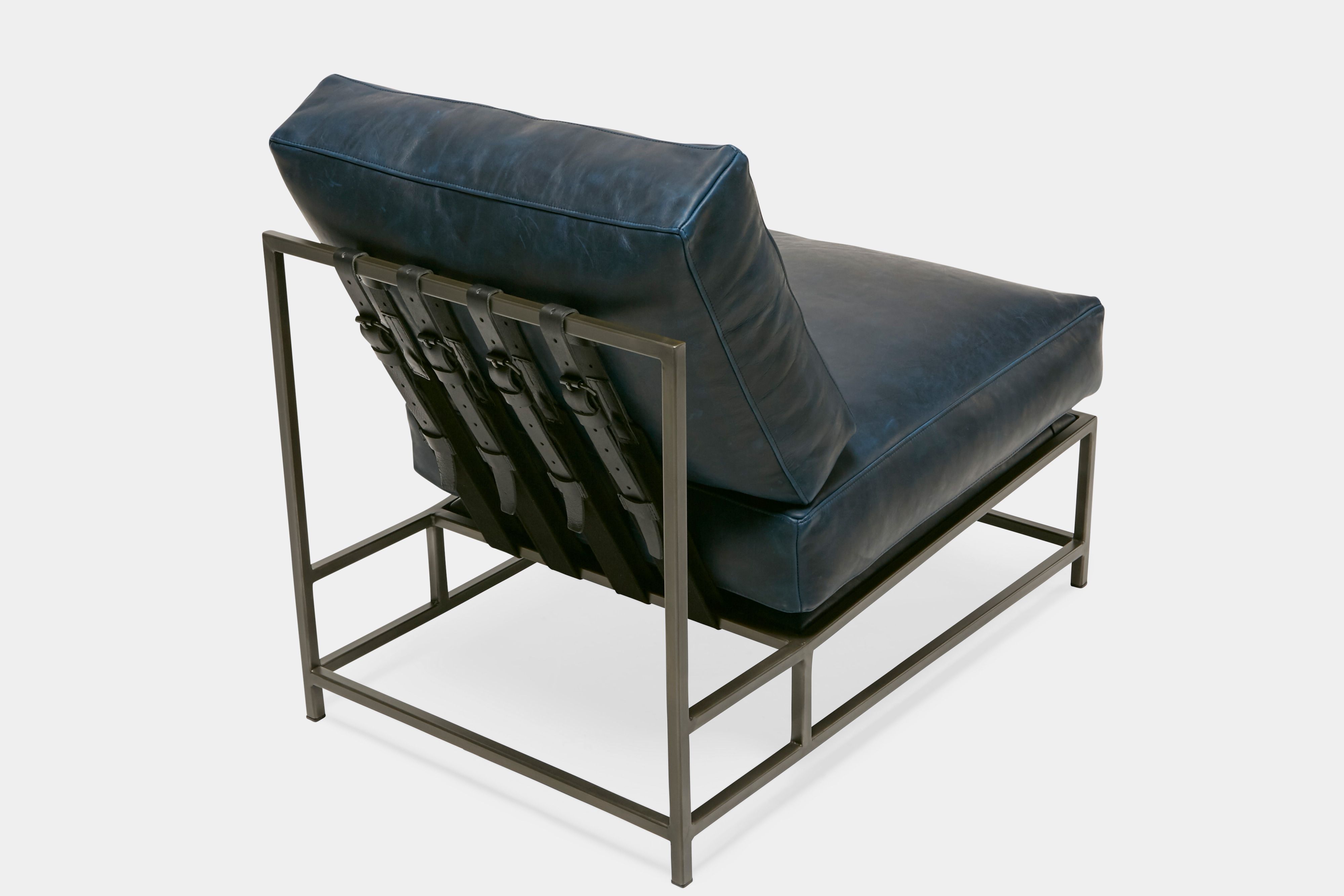 overhead view of lounge chair  with blue leather upholstery and black leather belts on antique nickel metal frame