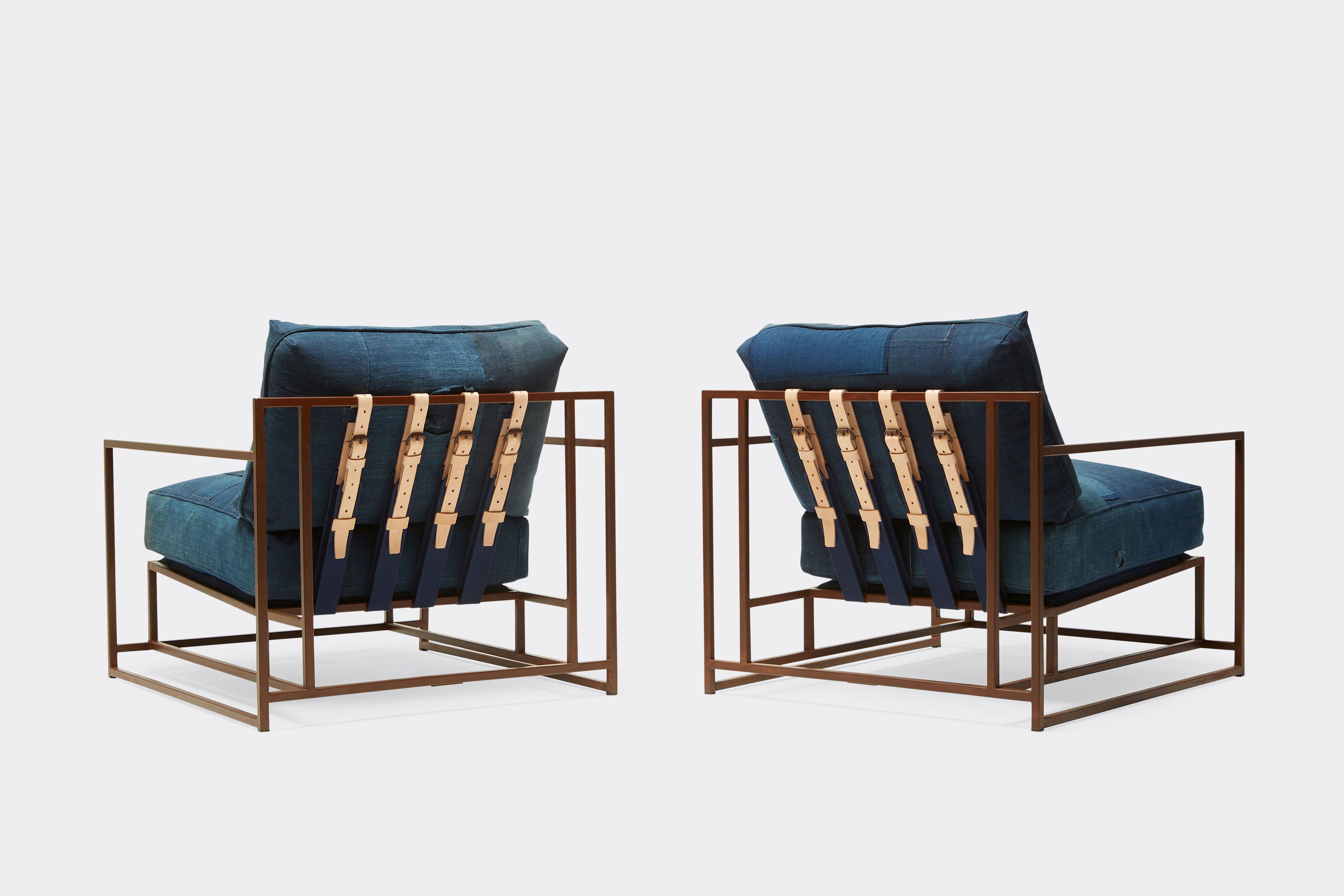 back of two armchairs with vintage boro upholstery and tan leather belts on marbled rust metal frame