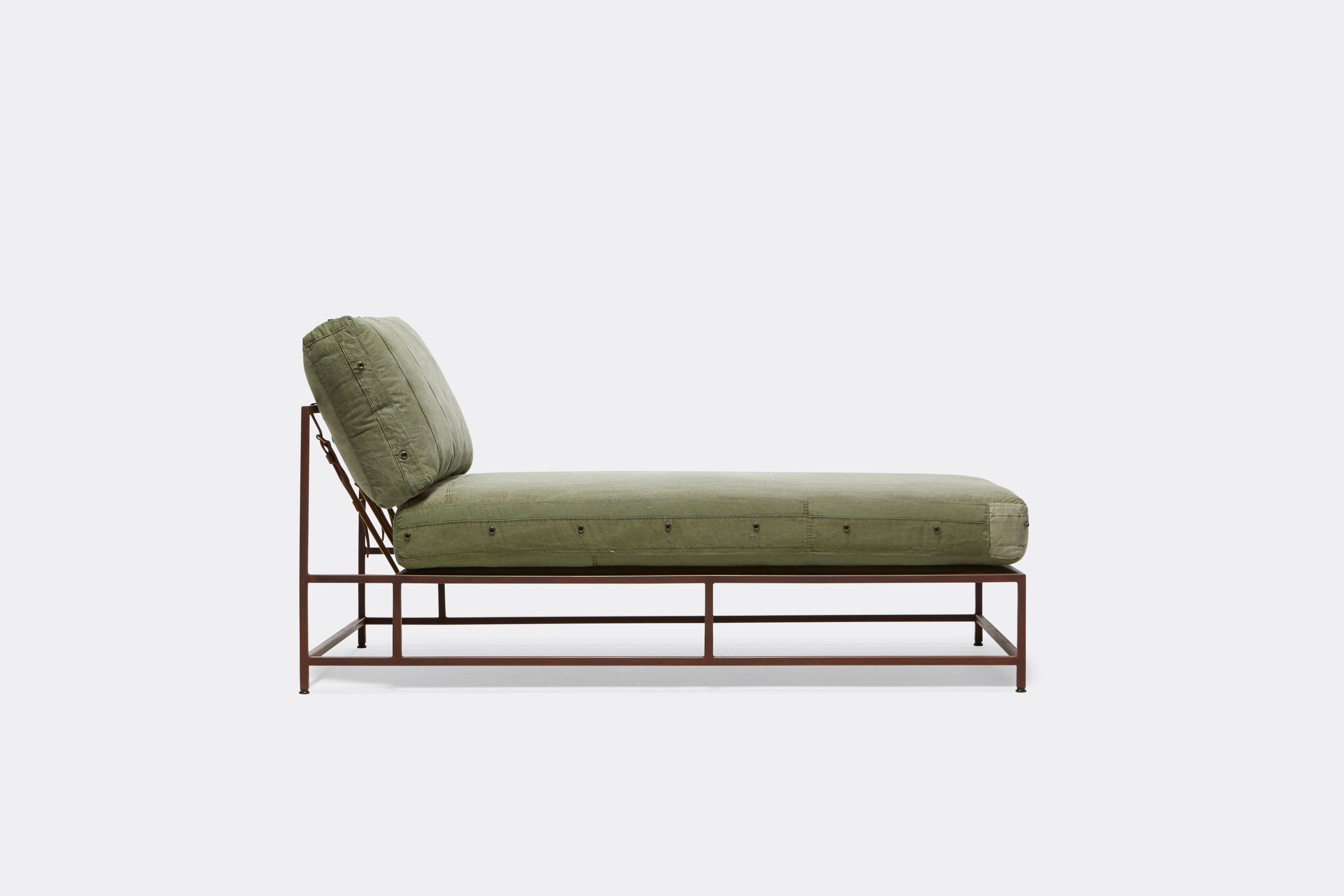 Sideview of lounge chaise with military canvas upholstery and marble rust metal frame