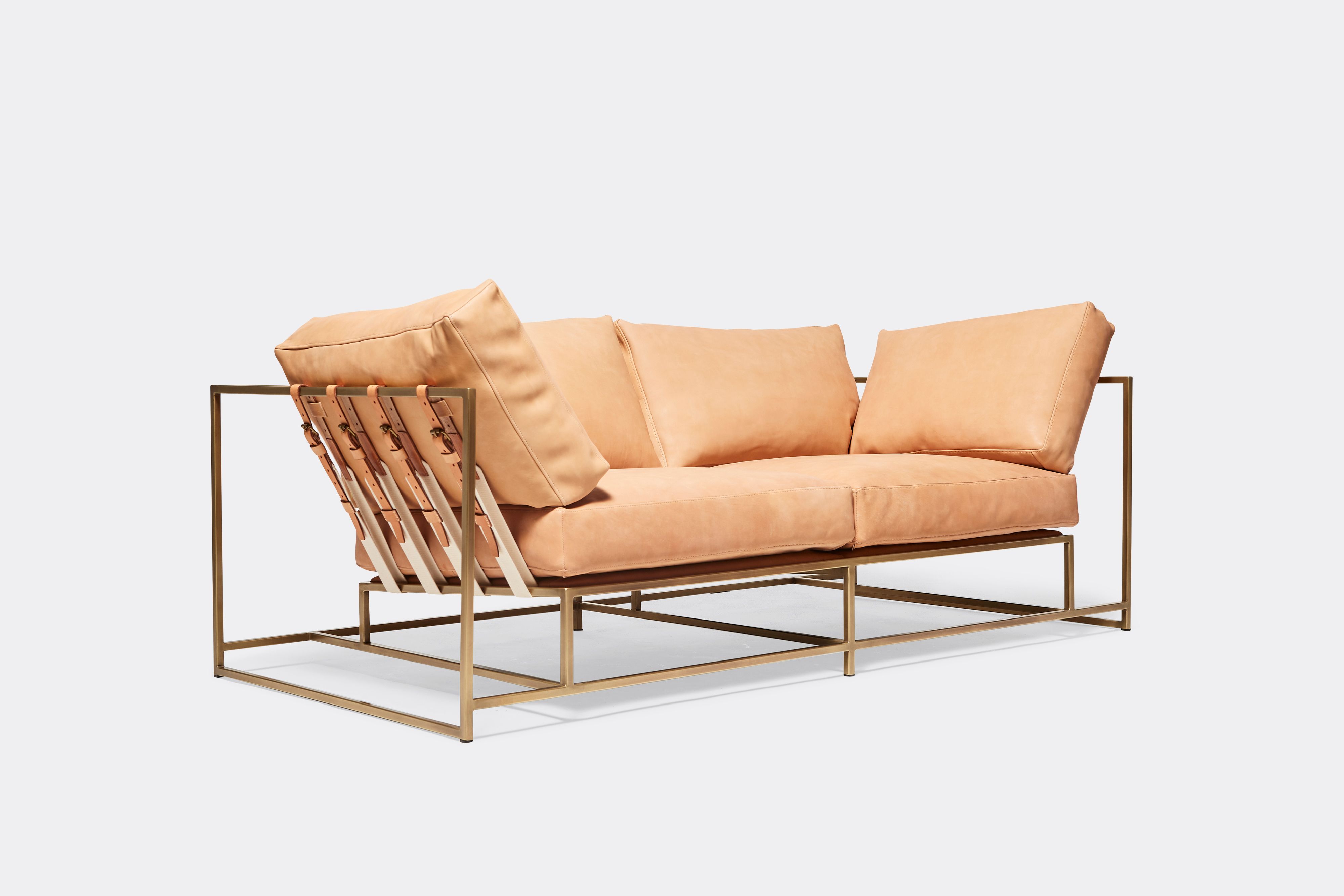 side of two seat sofa veg tan leather upholstery and veg tan leather belts on antique brass metal frame