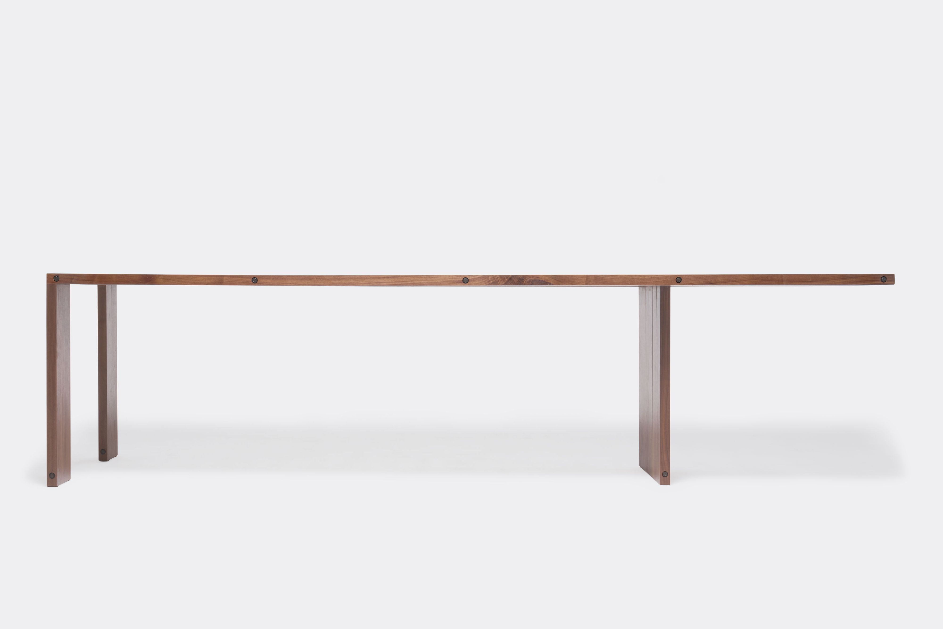 a long walnut wooden table on a white background .