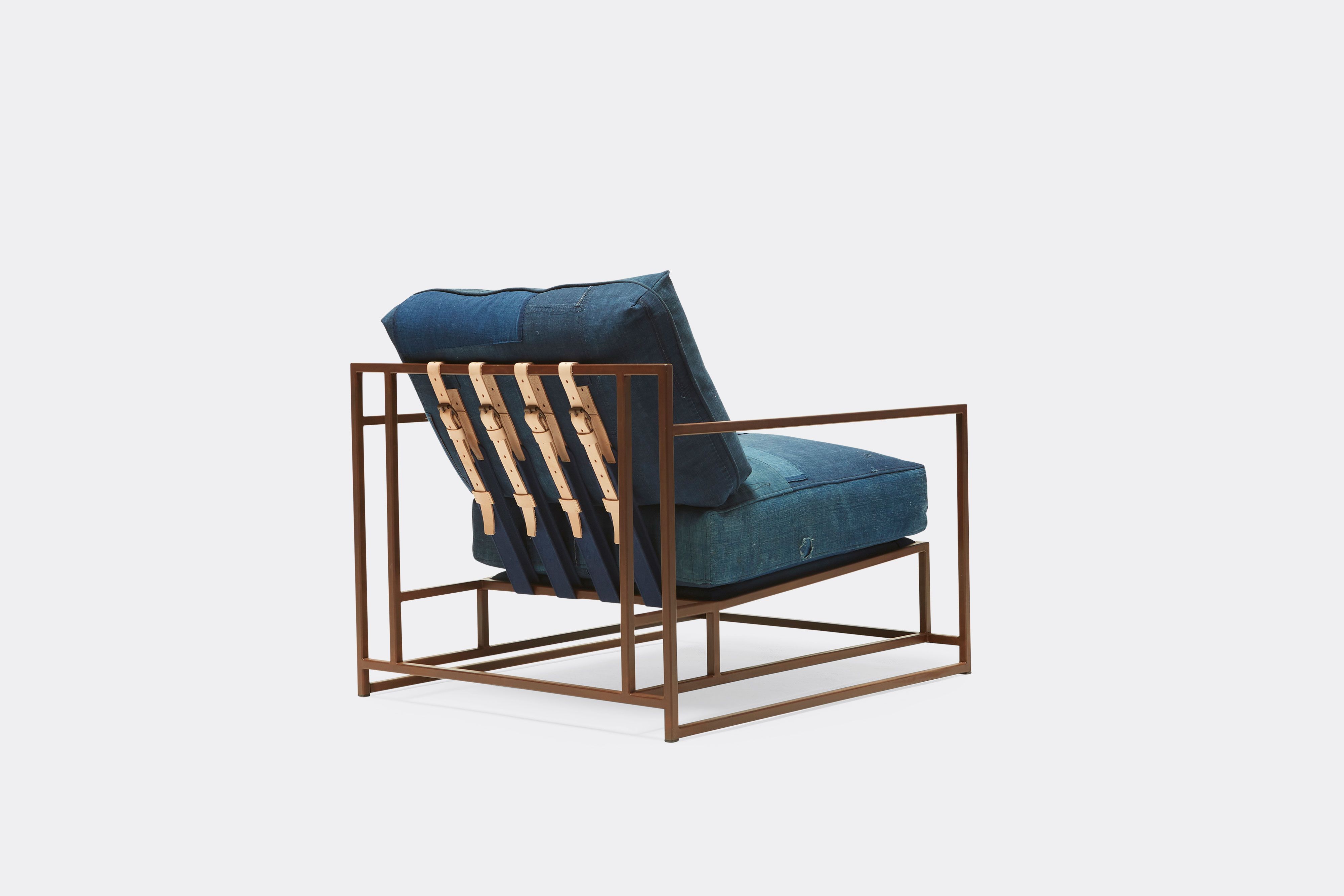 back of armchair with vintage boro upholstery and tan leather belts on marbled rust metal frame
