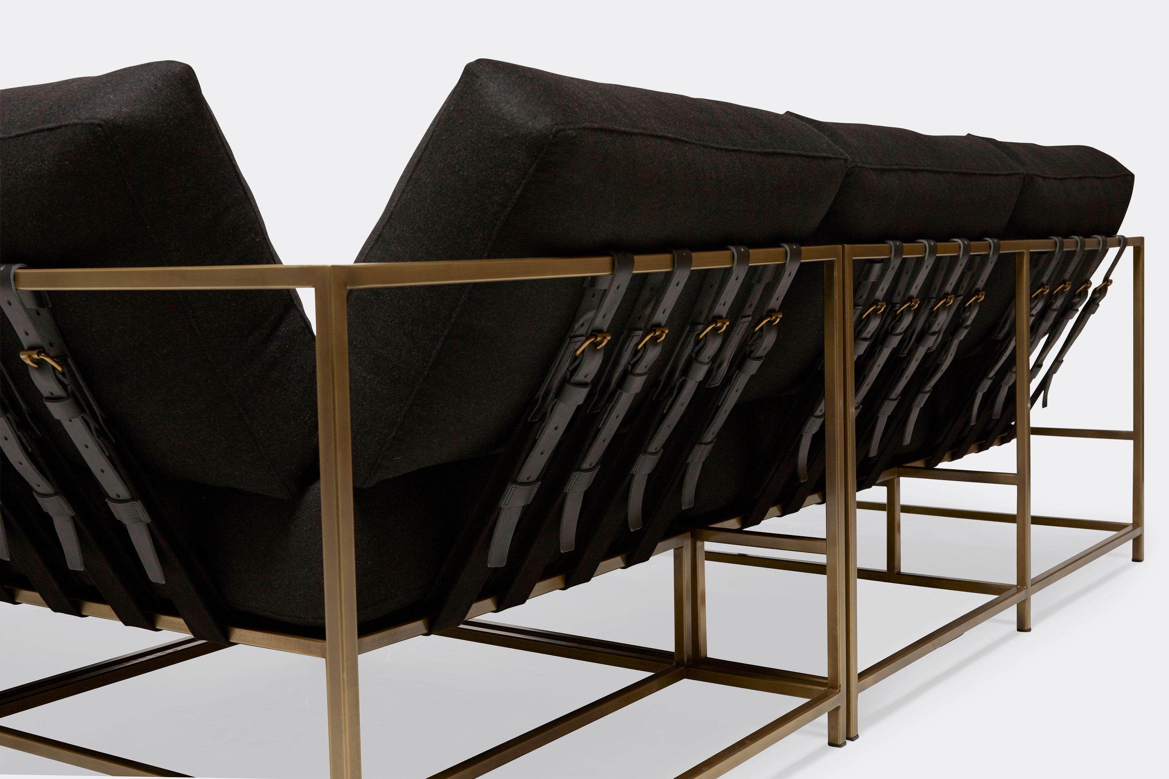 detail of sectional with black wool upholstery on antique brass metal frame