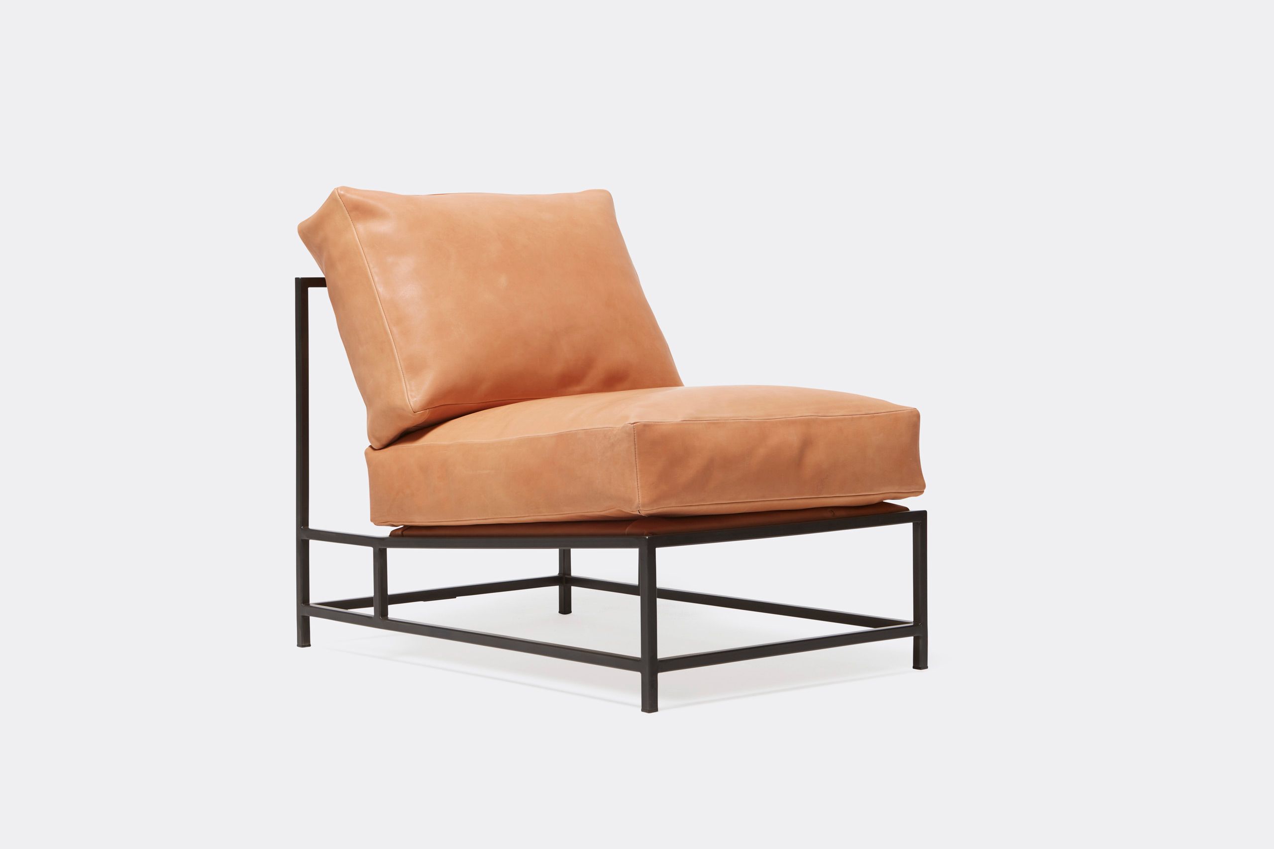 a tan leather chair with a metal frame and leather and webbing supporting belts shown on a white background .