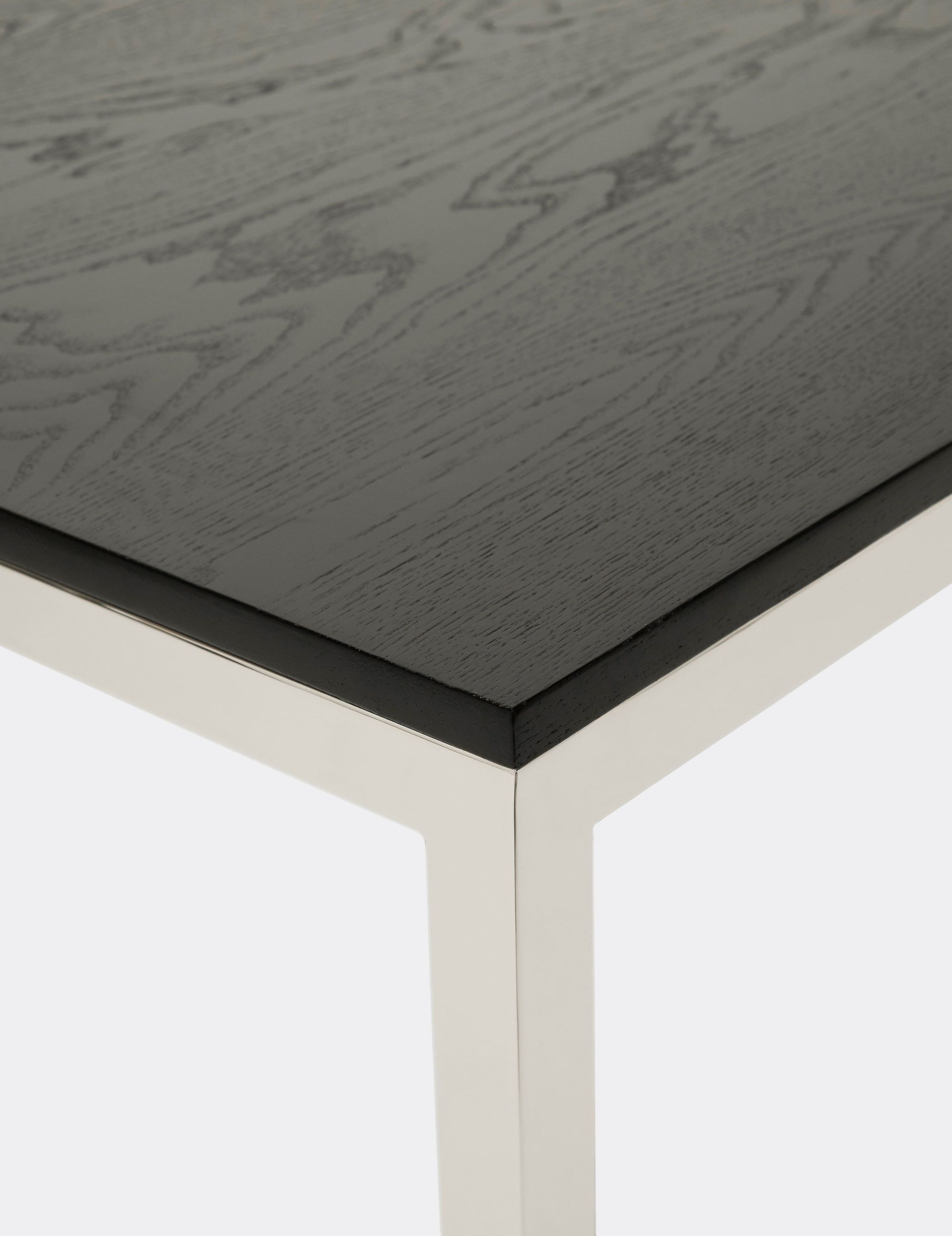 a black wooden table with a polished steel frame on a white background .