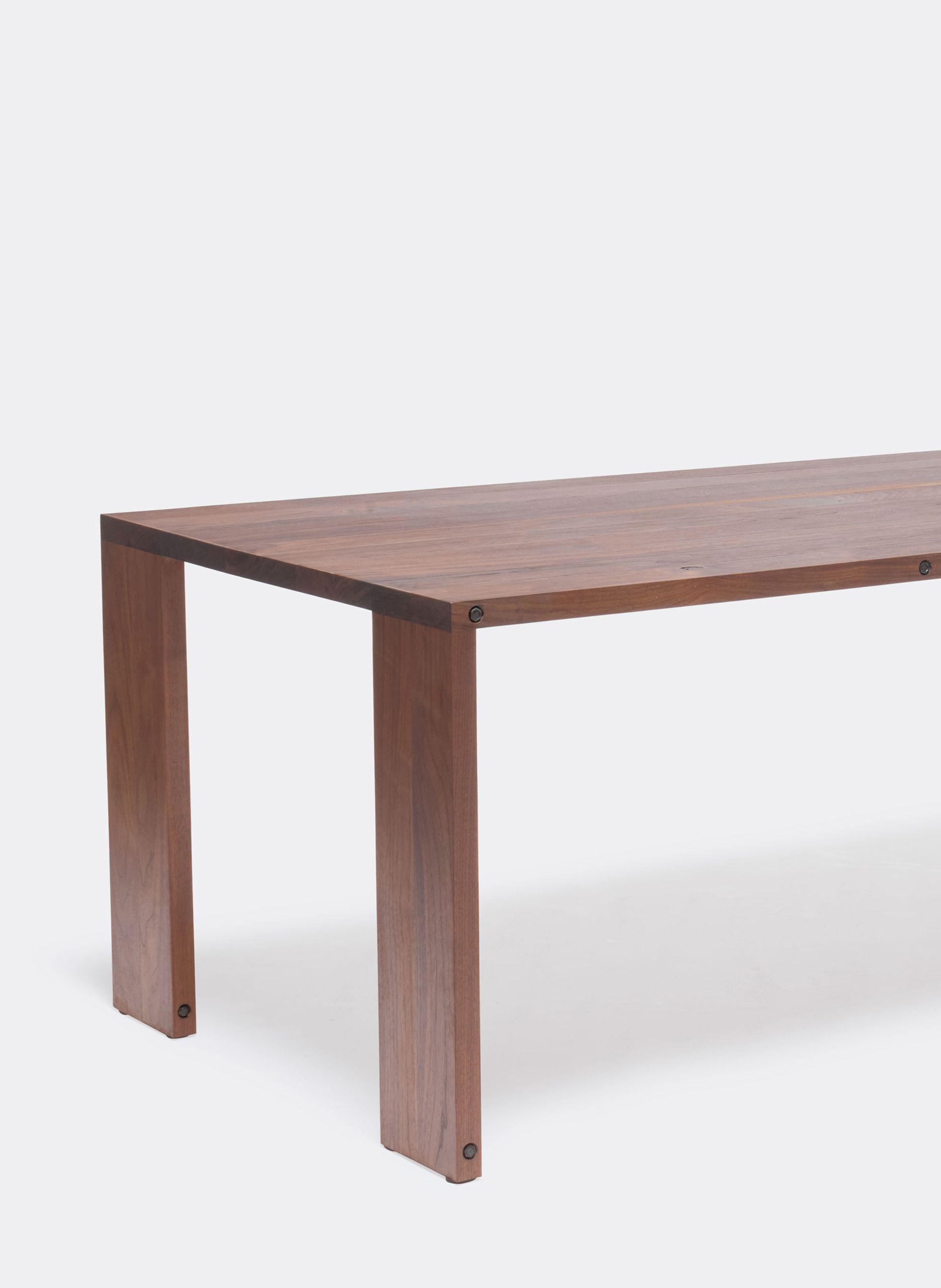 a long walnut wooden table on a white background .