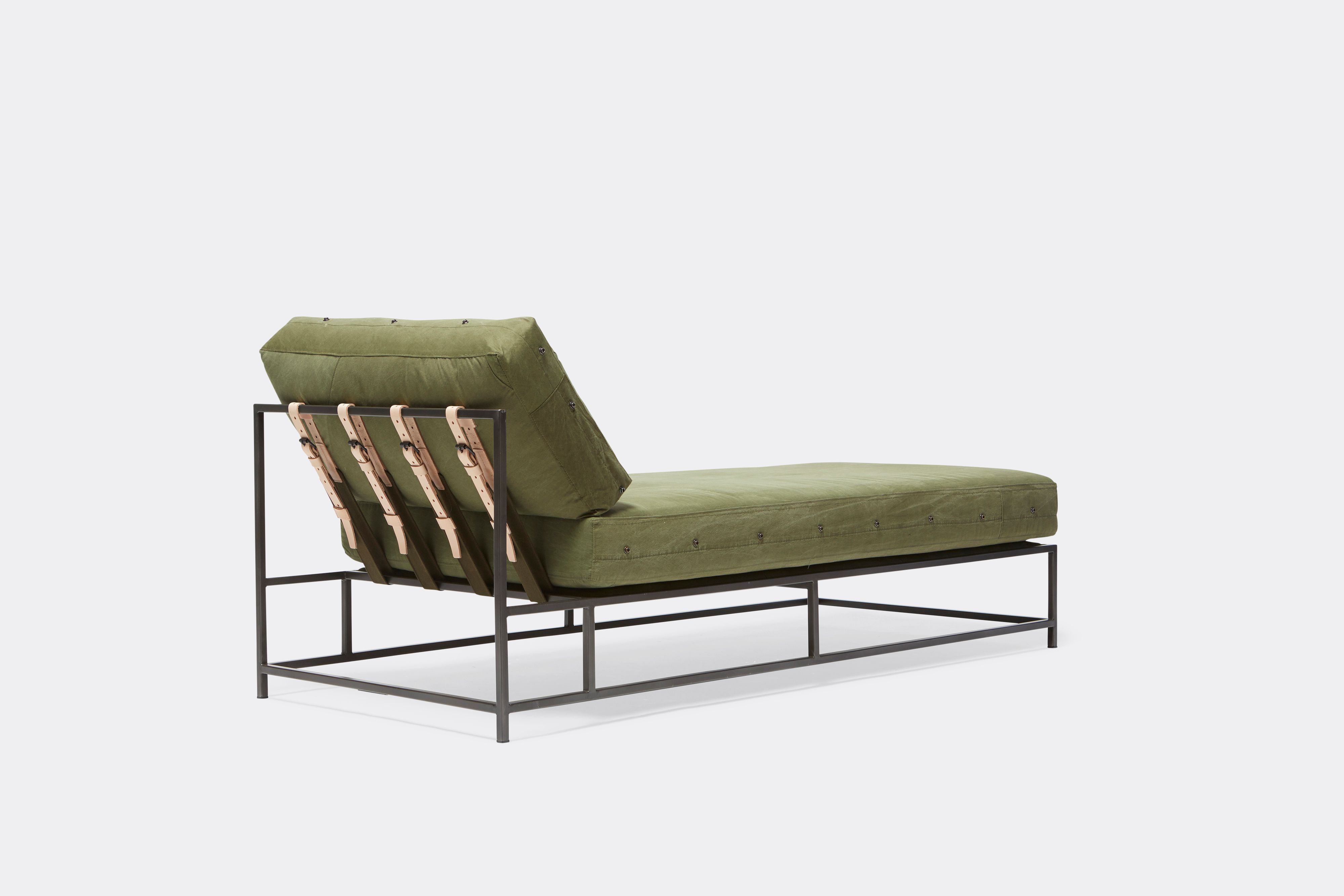 back view of military canvas chaise lounge with blackened steel frame and leather belts