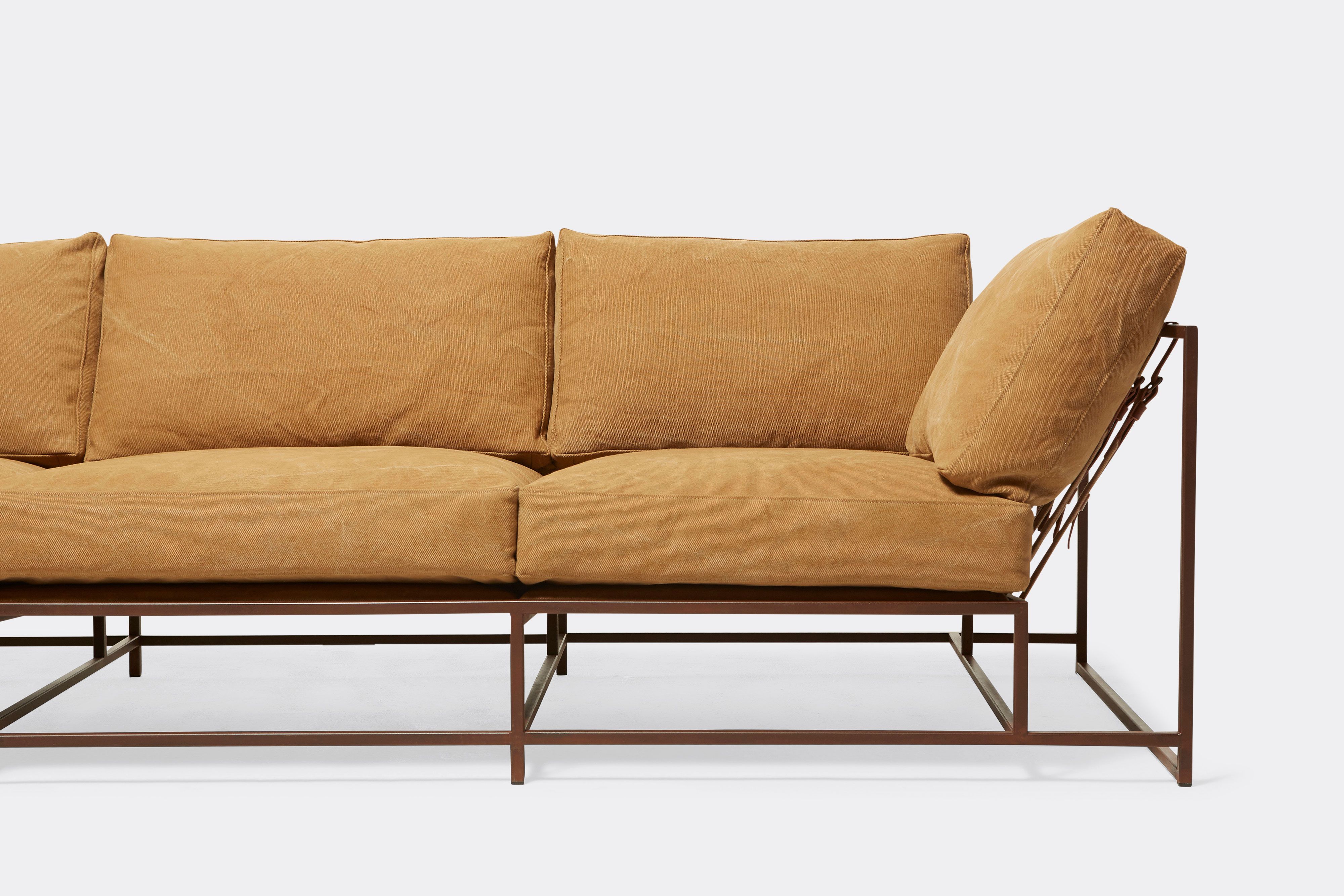 front detail of sofa with tan canvas upholstery on marble rust metal frame