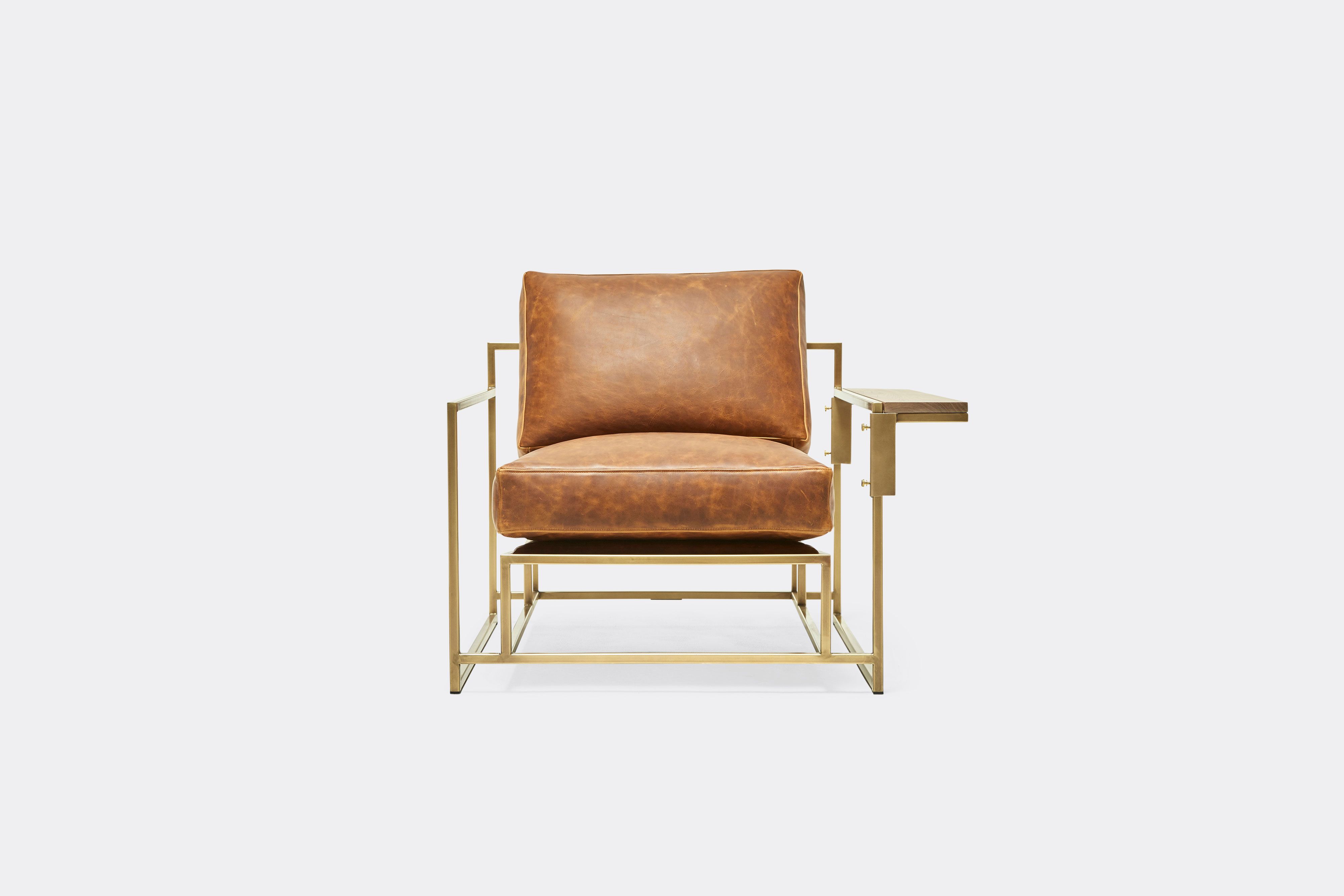 front of armchair with brown leather on antique brass metal frame and metal wing table