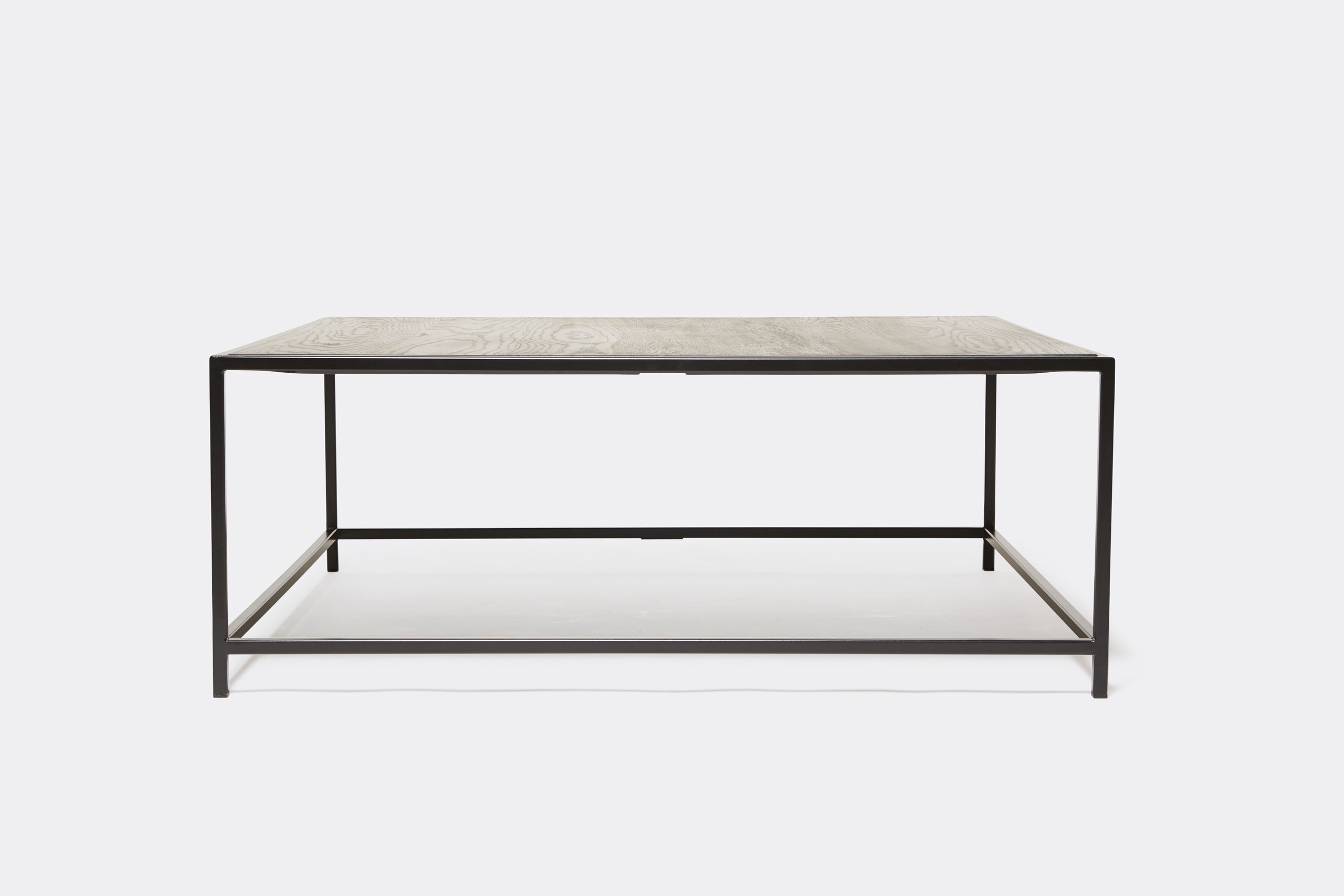 a black wood topped coffee table with a metal frame on a white background .