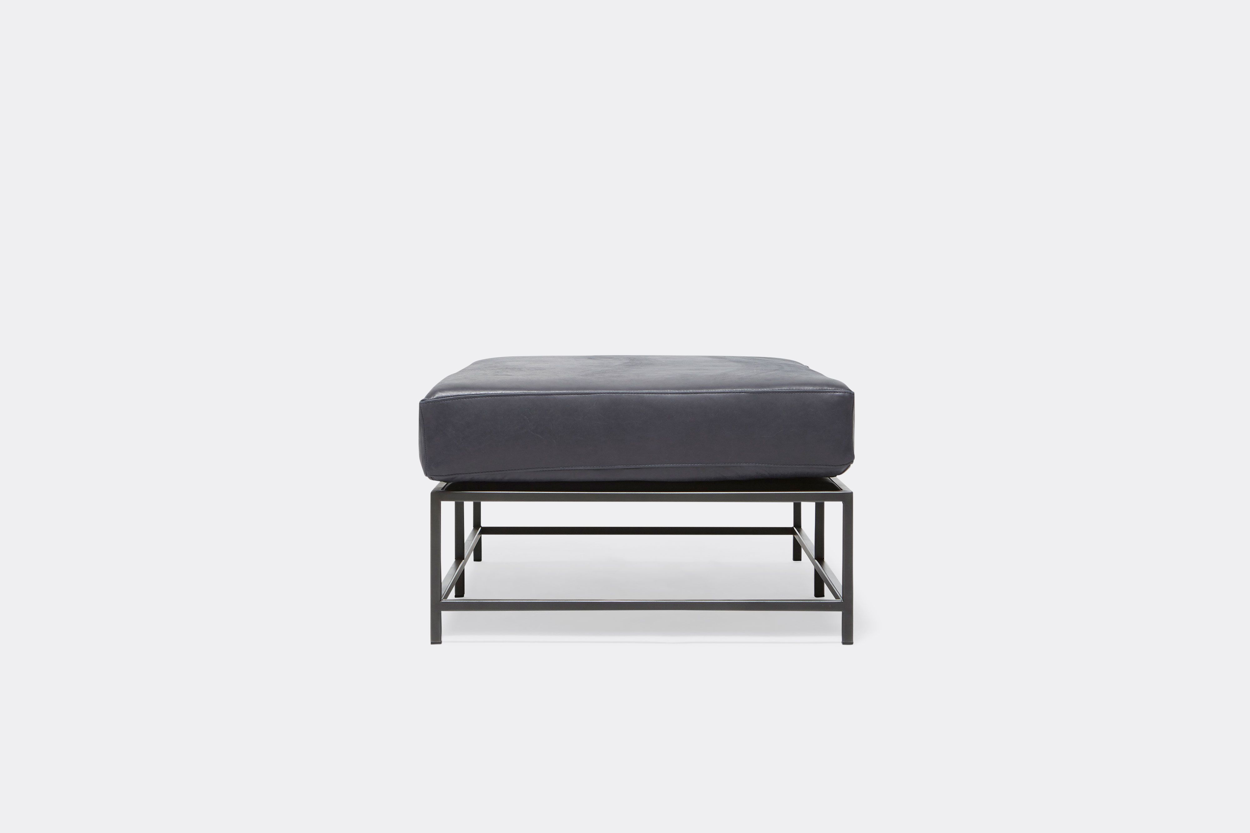 side of bench with blue leather upholstery on black metal frame