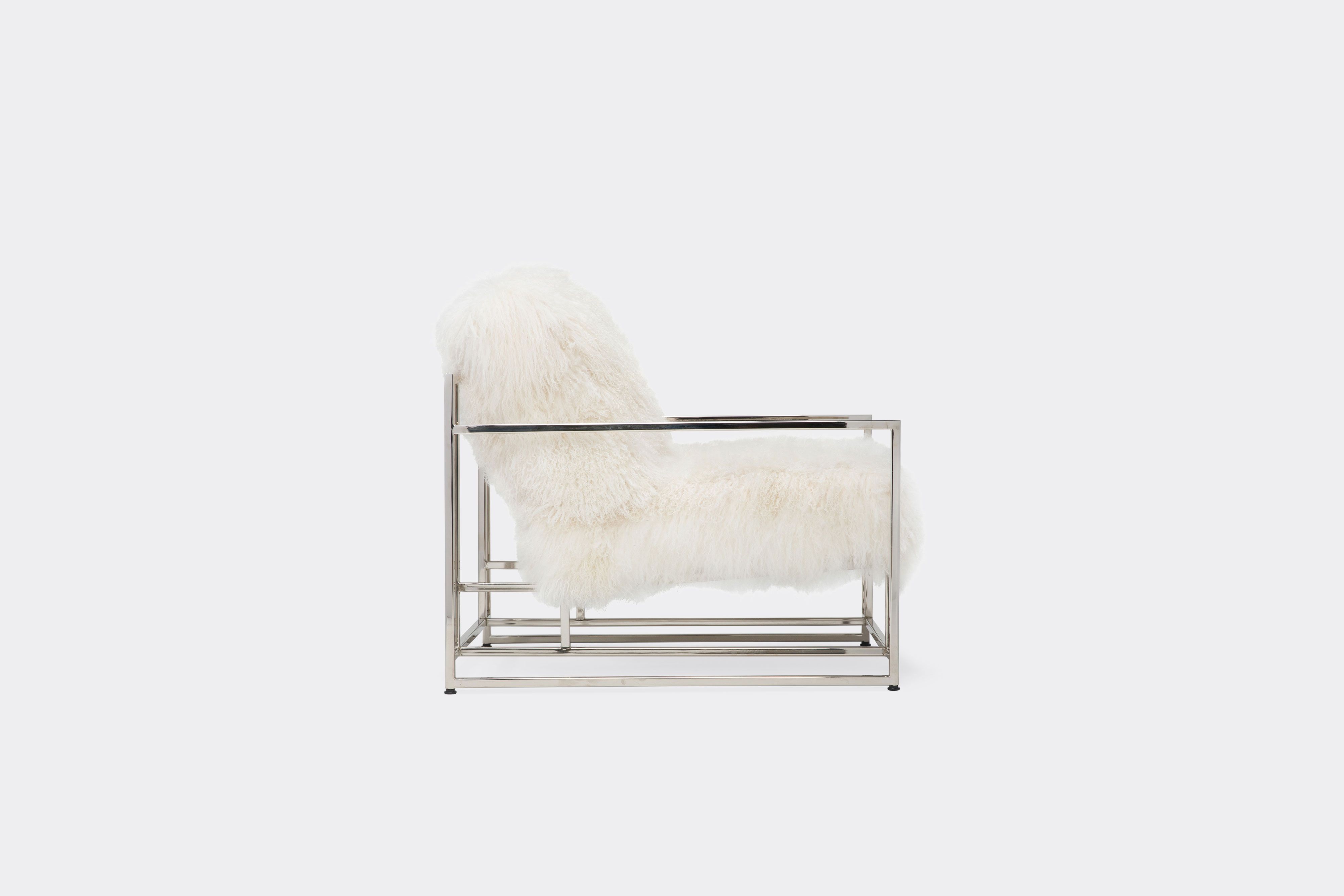 side of armchair with white sheepskin upholstery on polished nickel metal frame