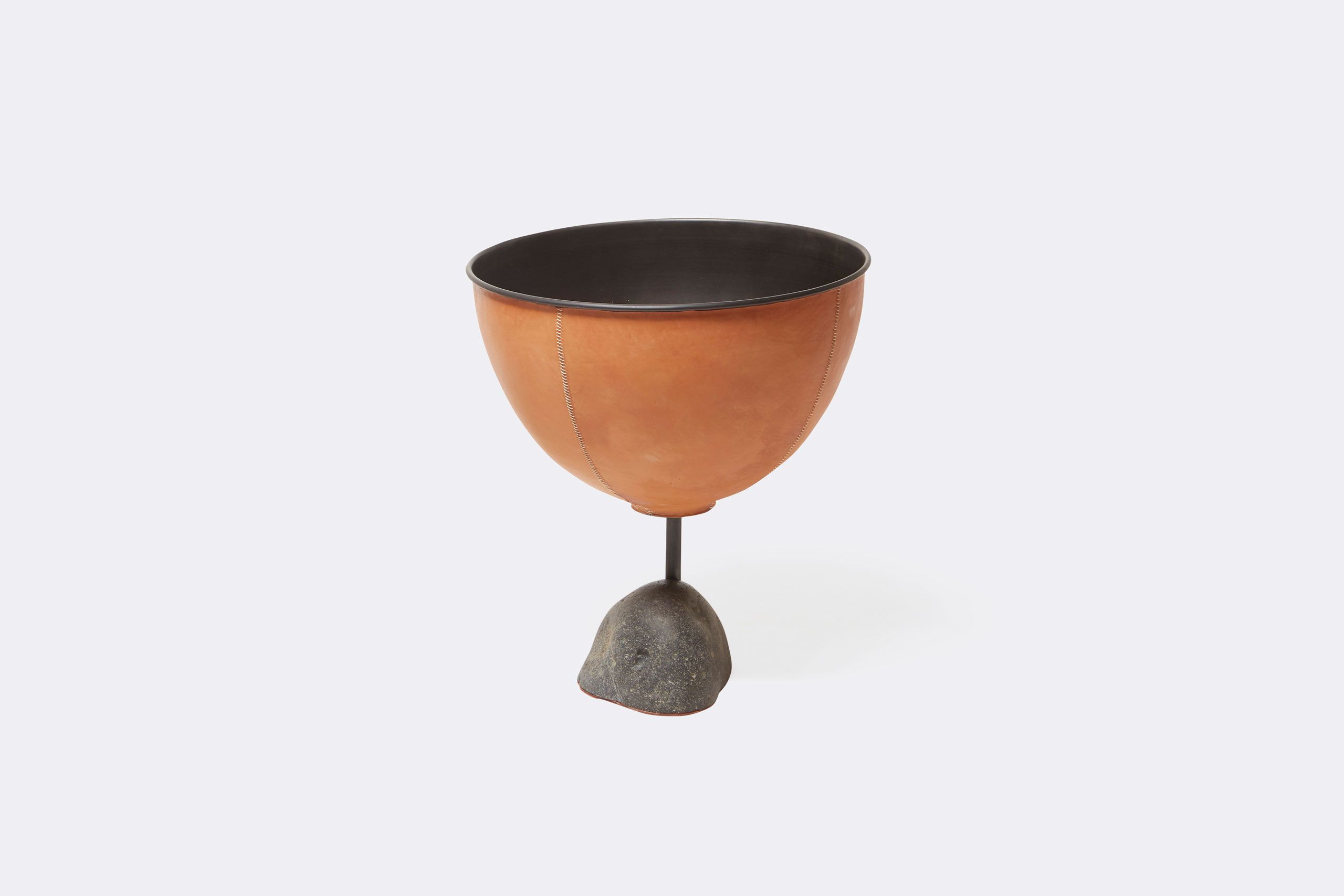 a leather wrapped steel planter with a steel and stone base shown on a white background .