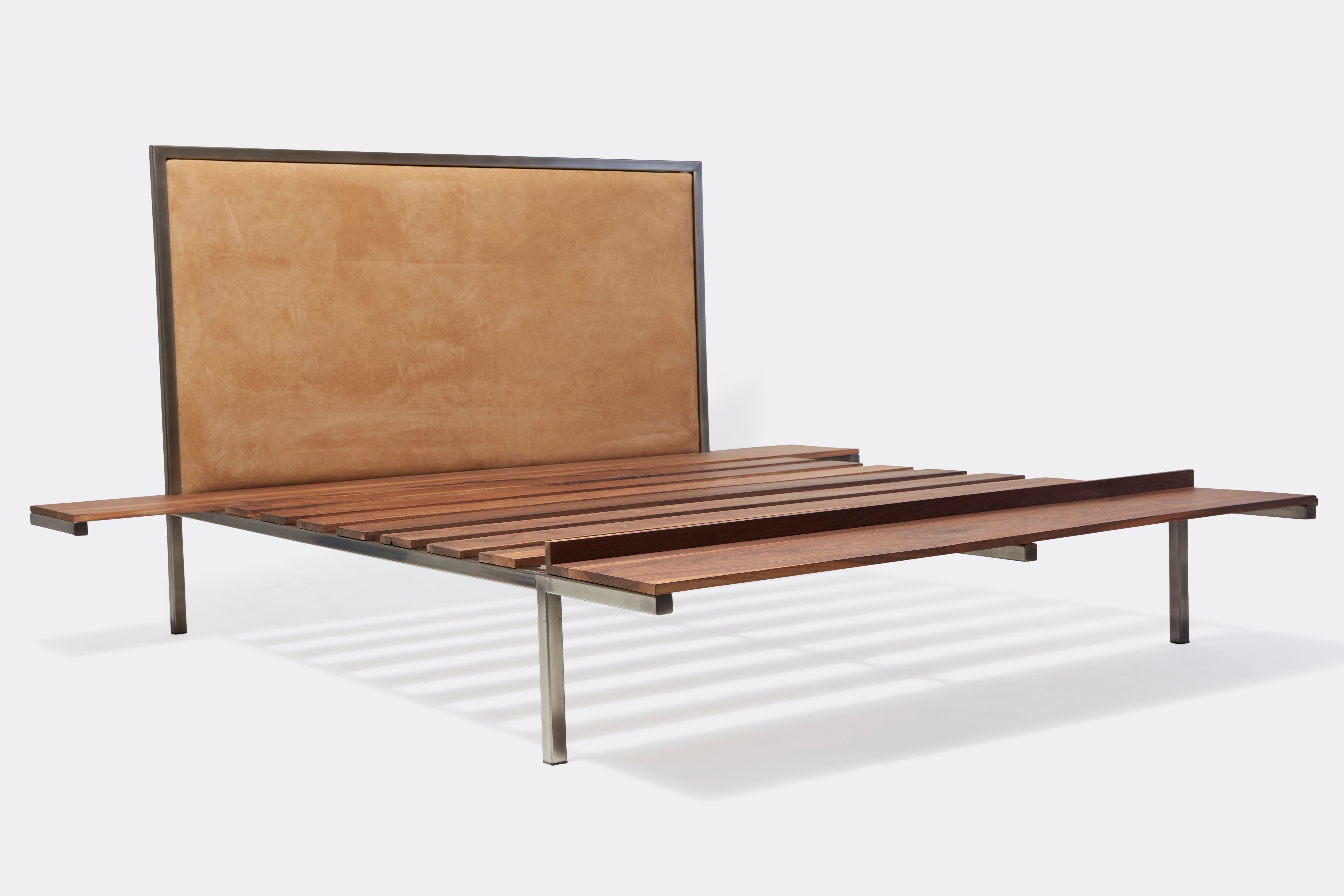 a steel and walnut wood bed with a brown leather headboard on a white background