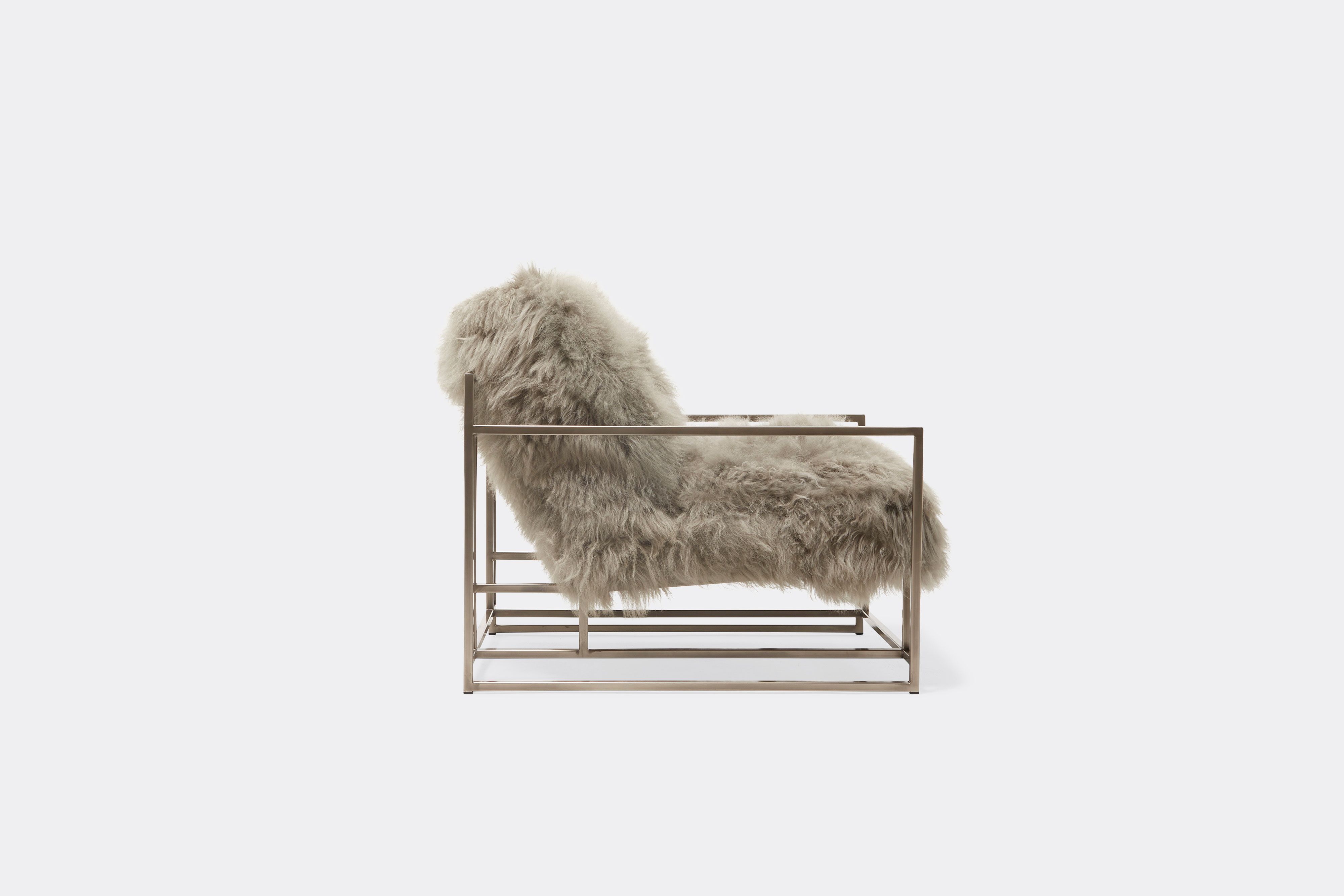 side of armchair with grey sheepskin upholstery on antique nickel frame