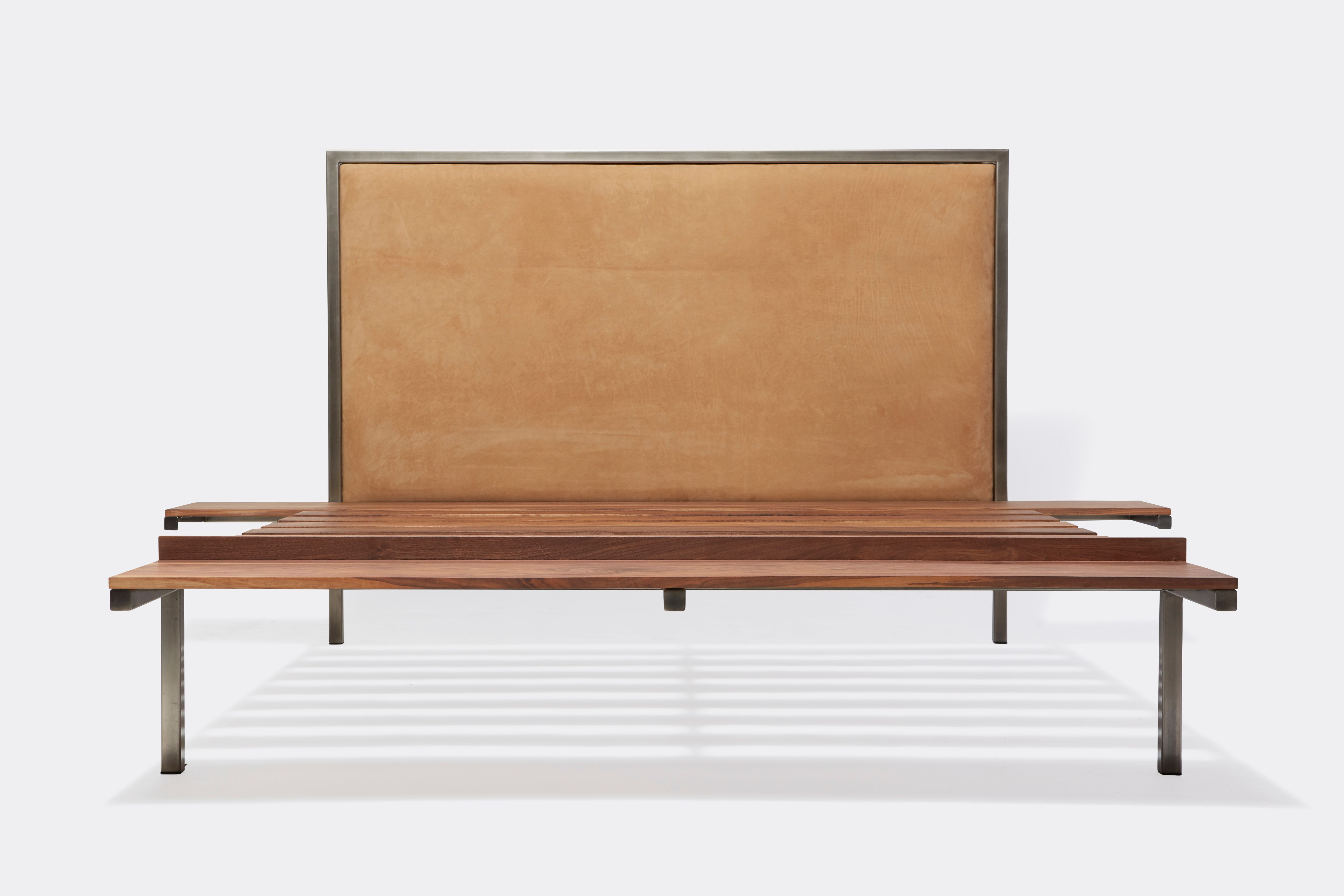 a steel and walnut wood bed with a brown leather headboard on a white background