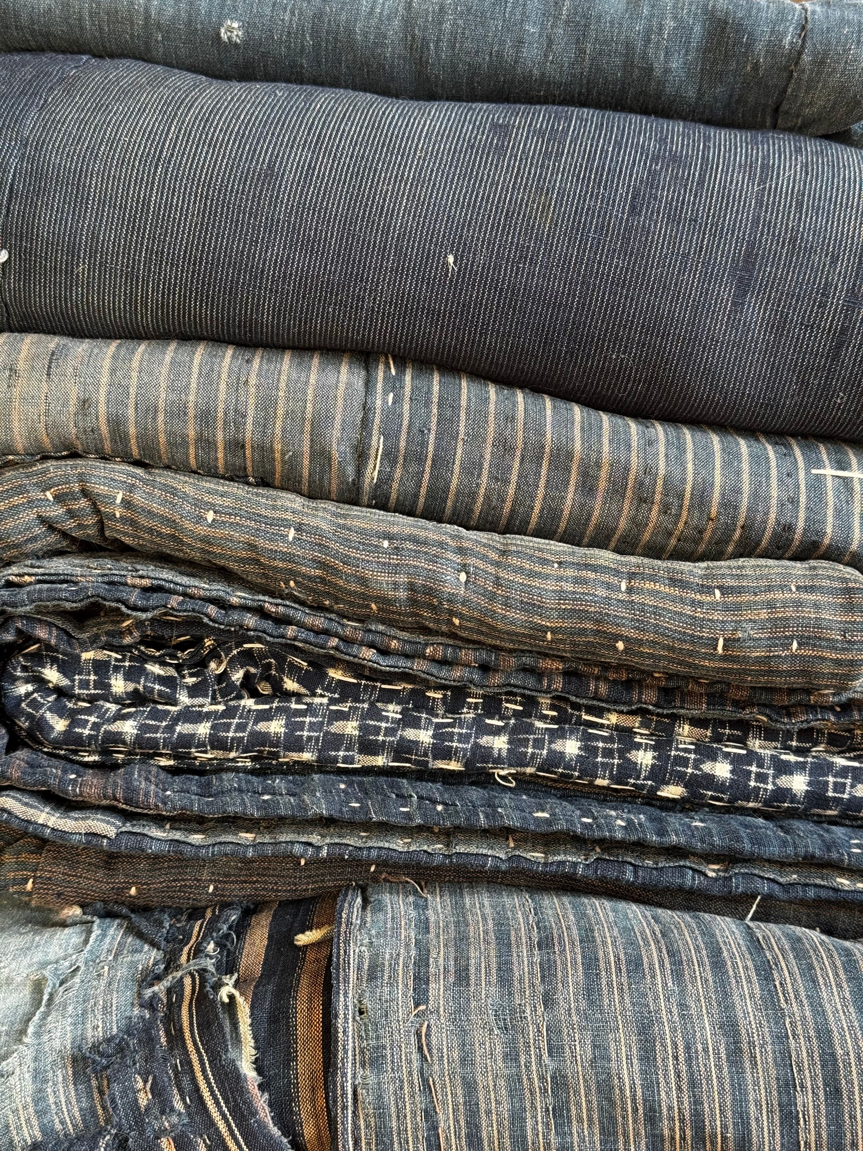 there are many different types of blue quilted and vintage fabrics stacked on top of each other .
