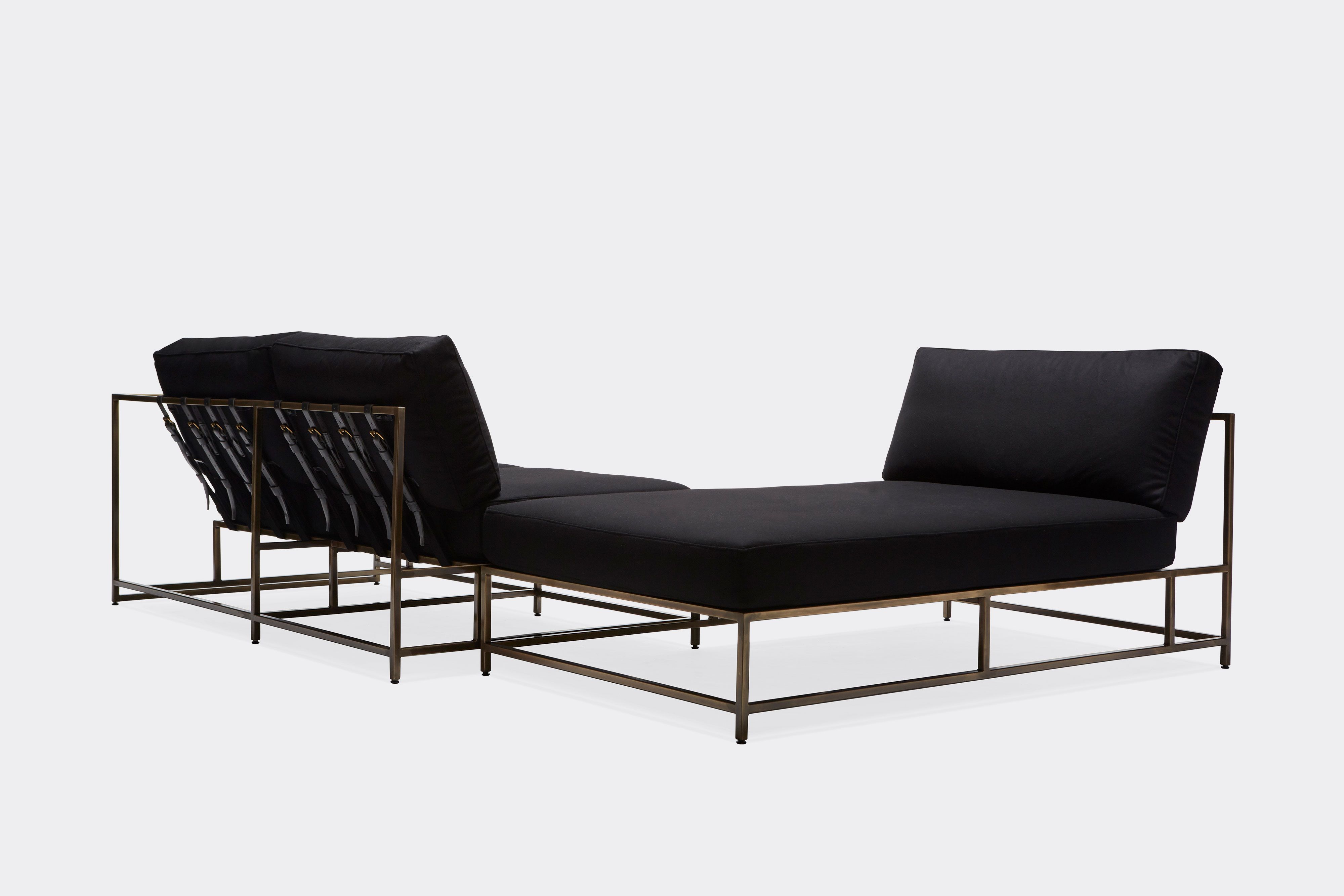 sectional with black wool upholstery and black leather belts on antique brass metal frame