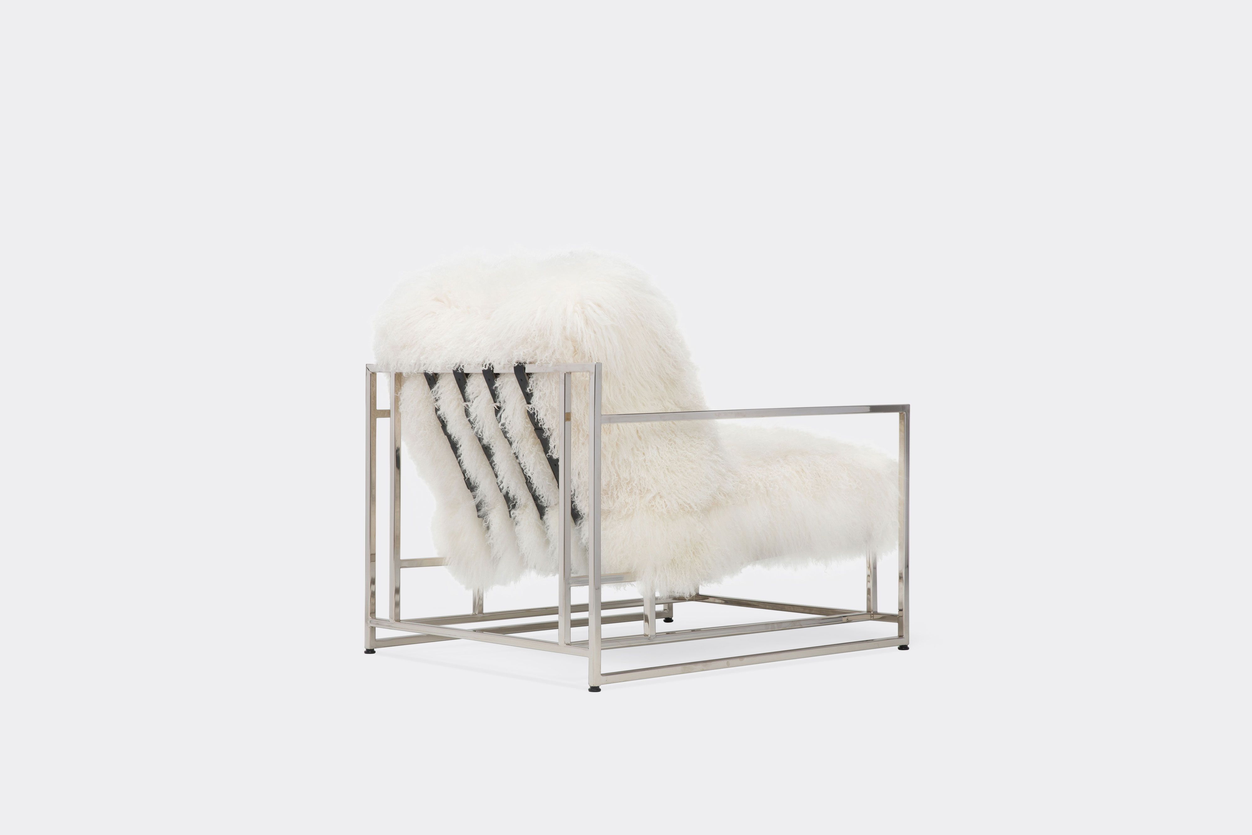 back of armchair with white sheepskin upholstery and black leather belts on polished nickel metal frame