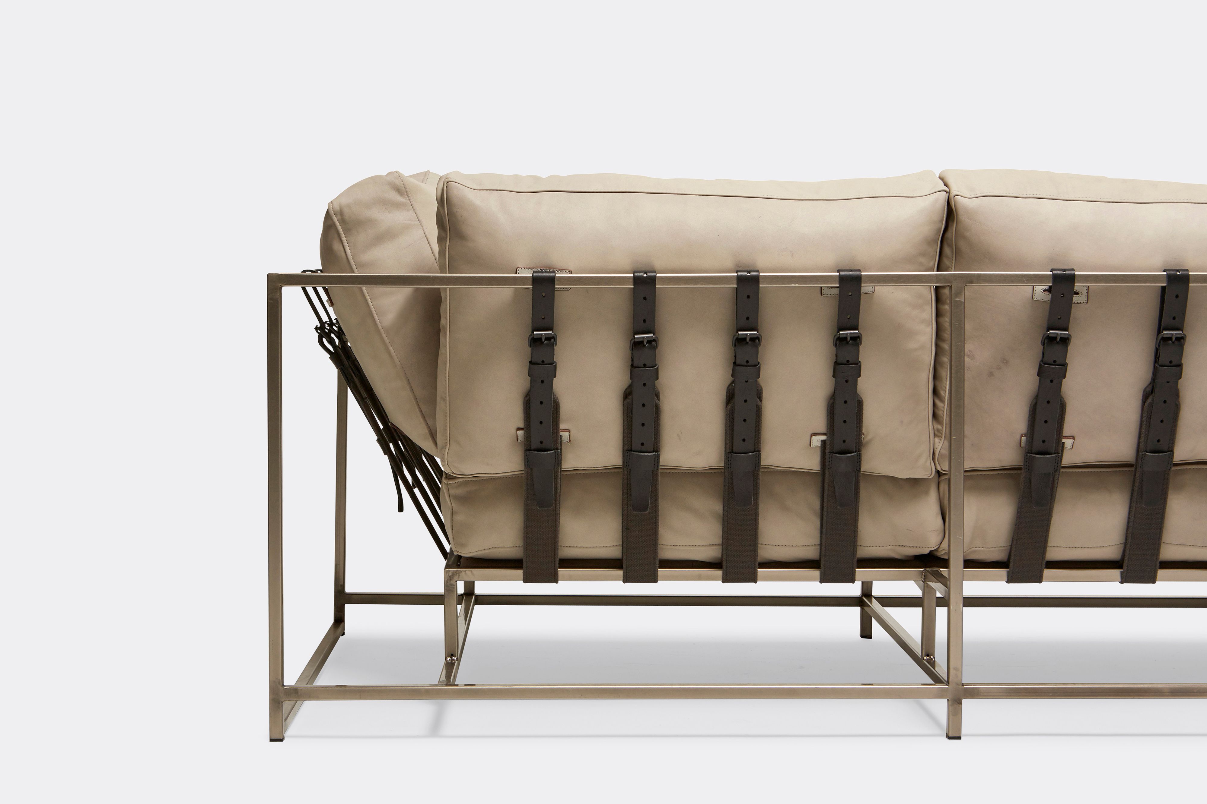 back of Sofa with cream leather upholstery and black leather belts on antique nickel metal frame